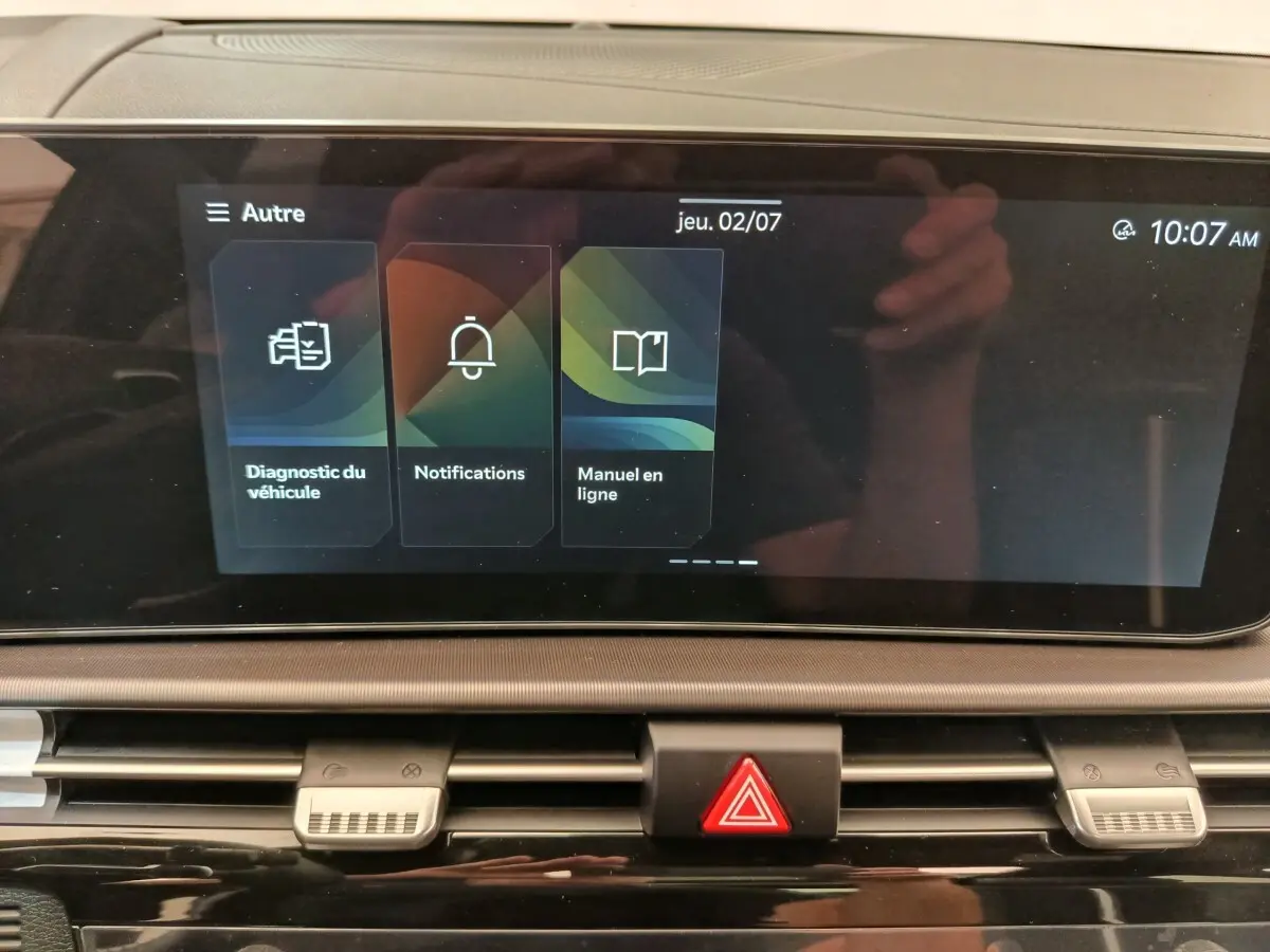 Écran tactile central affichant le menu diagnostic et notifications dans le tableau de bord du Kia Sportage gris clair.