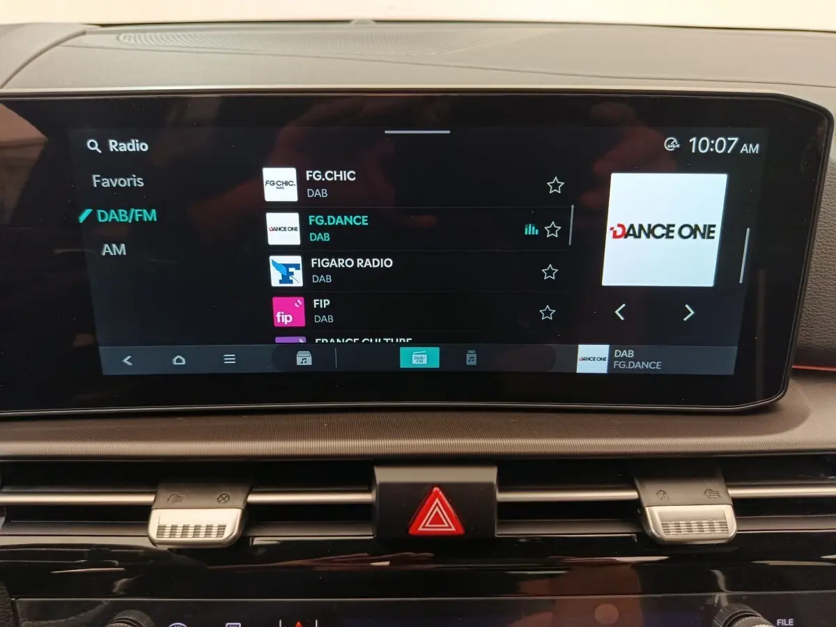 Écran tactile central du tableau de bord du Kia Sportage gris clair, affichant les options radio DAB/FM.