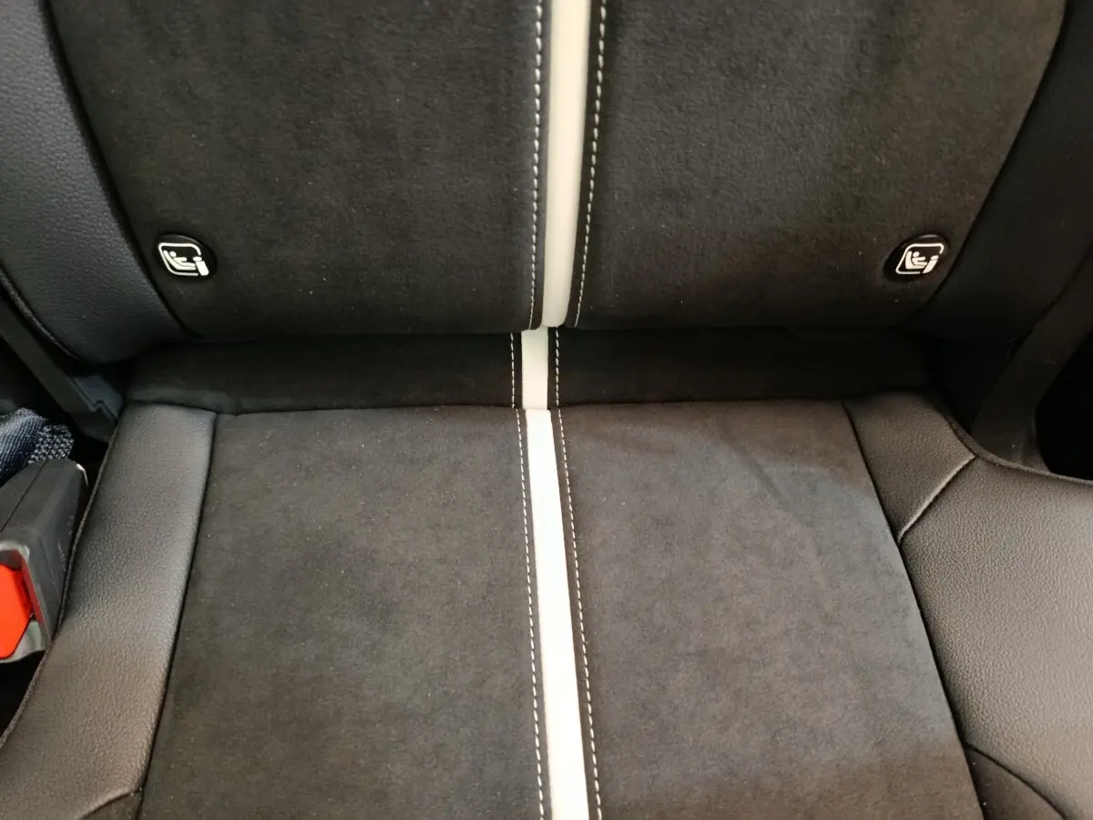 Gros plan sur la banquette arrière noire avec surpiqûres blanches et fixations ISOFIX visibles du KIA Sportage 2026.