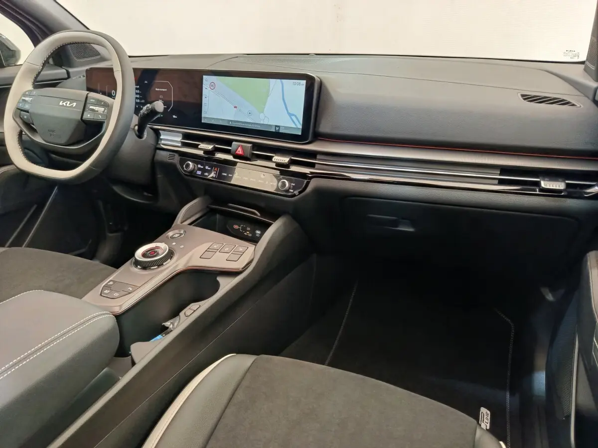 Vue intérieure de face droite du tableau de bord noir et gris avec écran tactile large et volant KIA clair du Kia Sportage 2026.