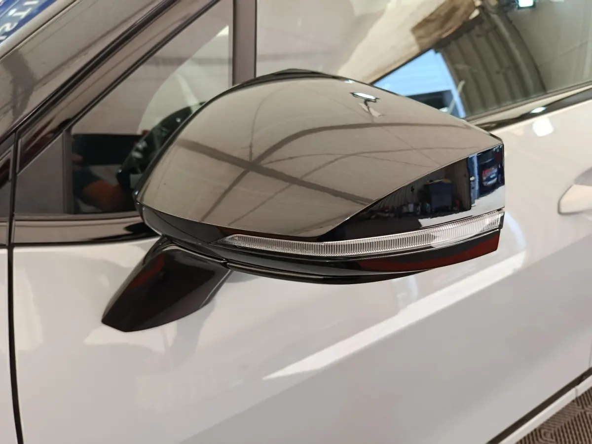 Rétroviseur extérieur noir sur porte gris clair d'un KIA Sportage 2026, vue latérale rapprochée côté gauche.