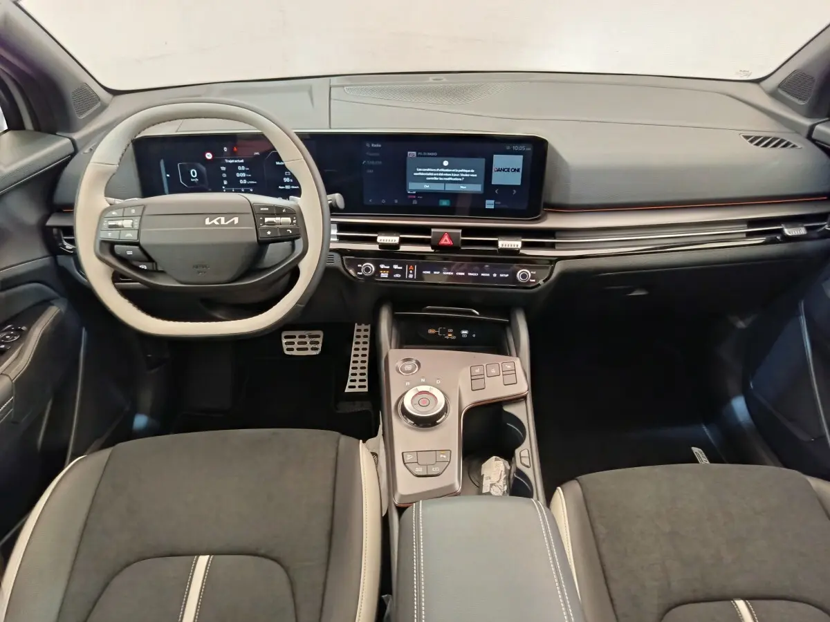 Vue intérieure avant du Kia Sportage 2026 gris clair, avec tableau de bord numérique et console centrale moderne.