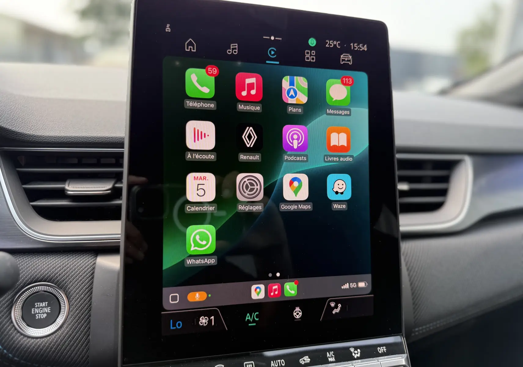 Écran tactile central du Renault Captur 2025 affichant des applications connectées, avec bouton Start Engine Stop à gauche.