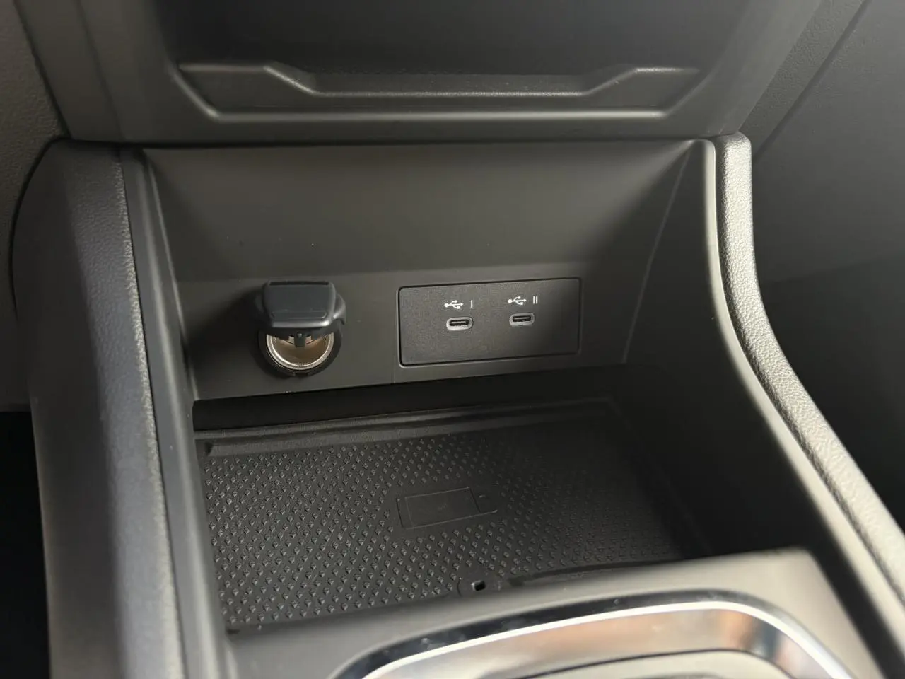 Gros plan sur la console centrale du Renault Captur 2025 avec ports USB-C et prise 12V, finition noire.