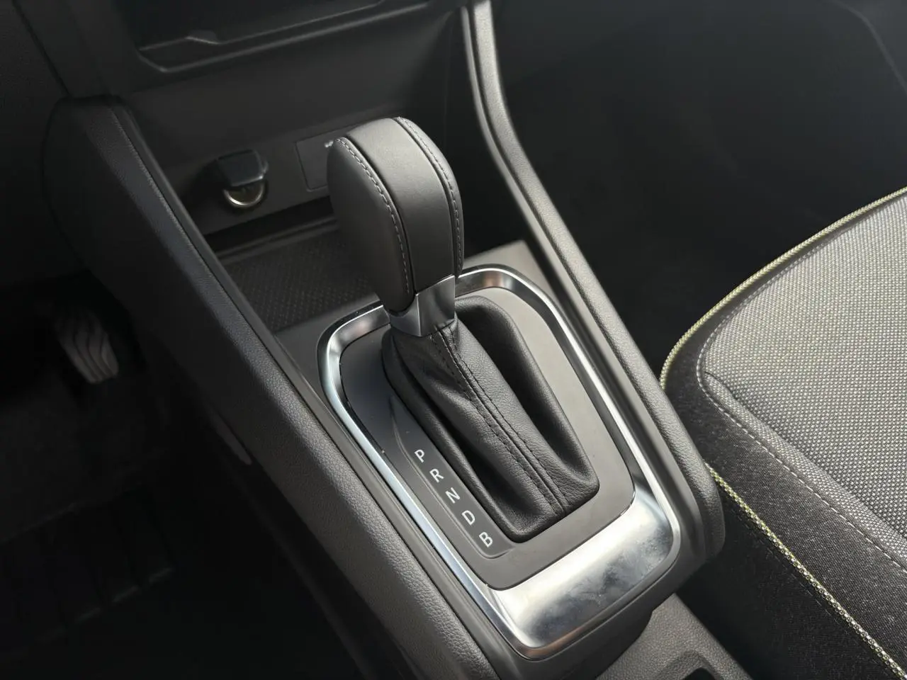 Le levier de vitesses automatique en cuir noir du Renault Captur hybride, vu en gros plan côté console centrale.