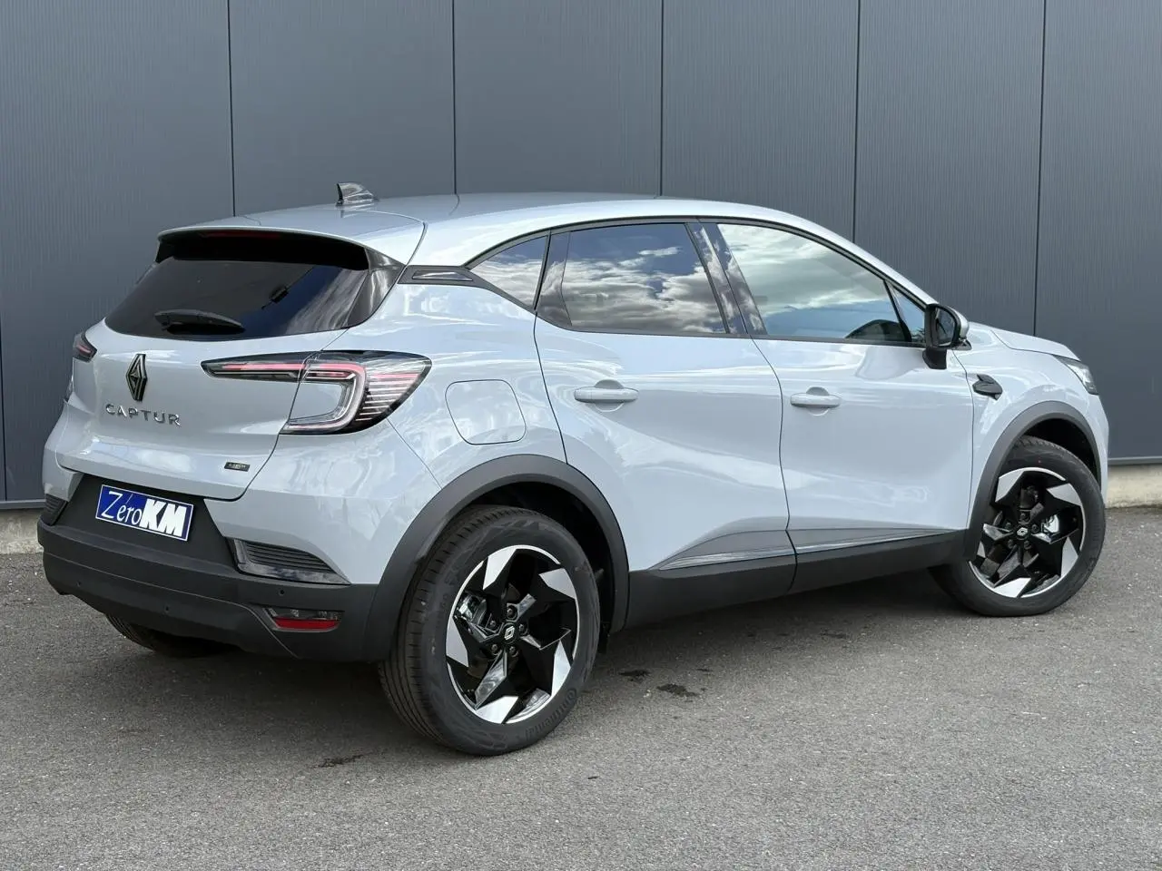 Vue 3/4 arrière droite du Renault Captur Gris Rafale 2025 avec jantes noires et toit gris Highland.