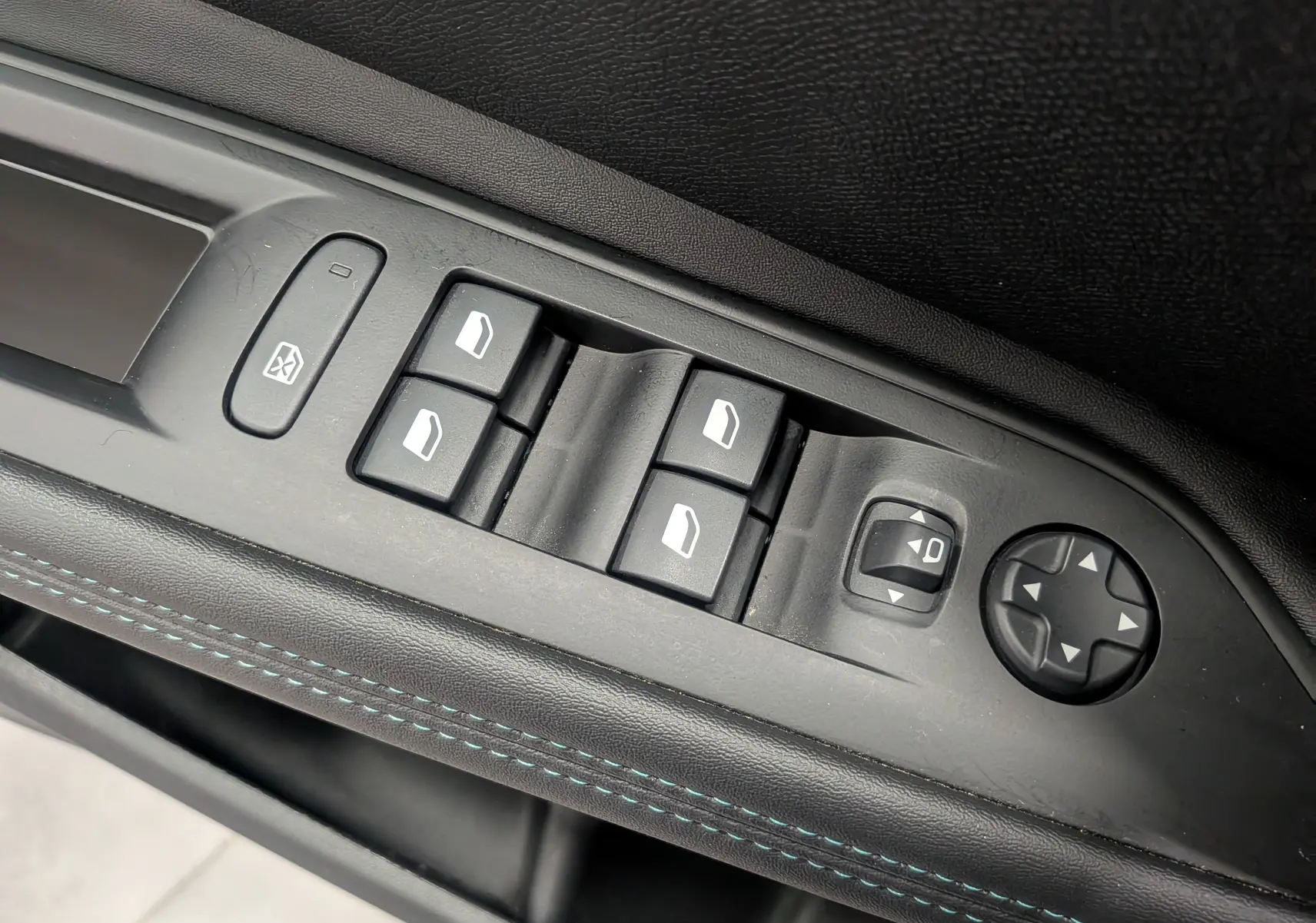 Gros plan sur les commandes des vitres et rétroviseurs côté conducteur du Peugeot 3008 noir Perla, finition Allure.
