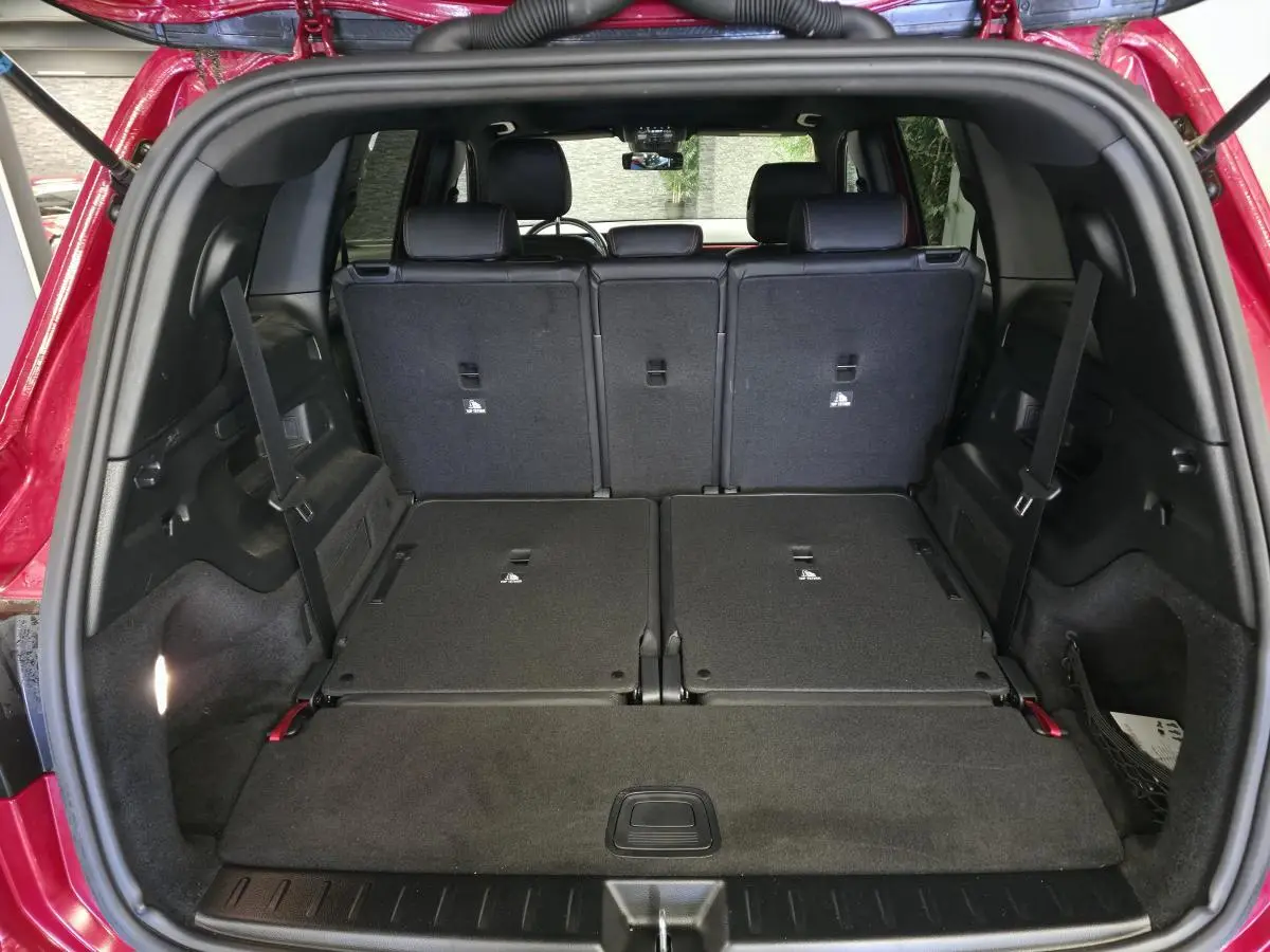 Vue arrière du coffre ouvert du Mercedes GLB rouge avec sièges rabattus et espace de chargement étendu.