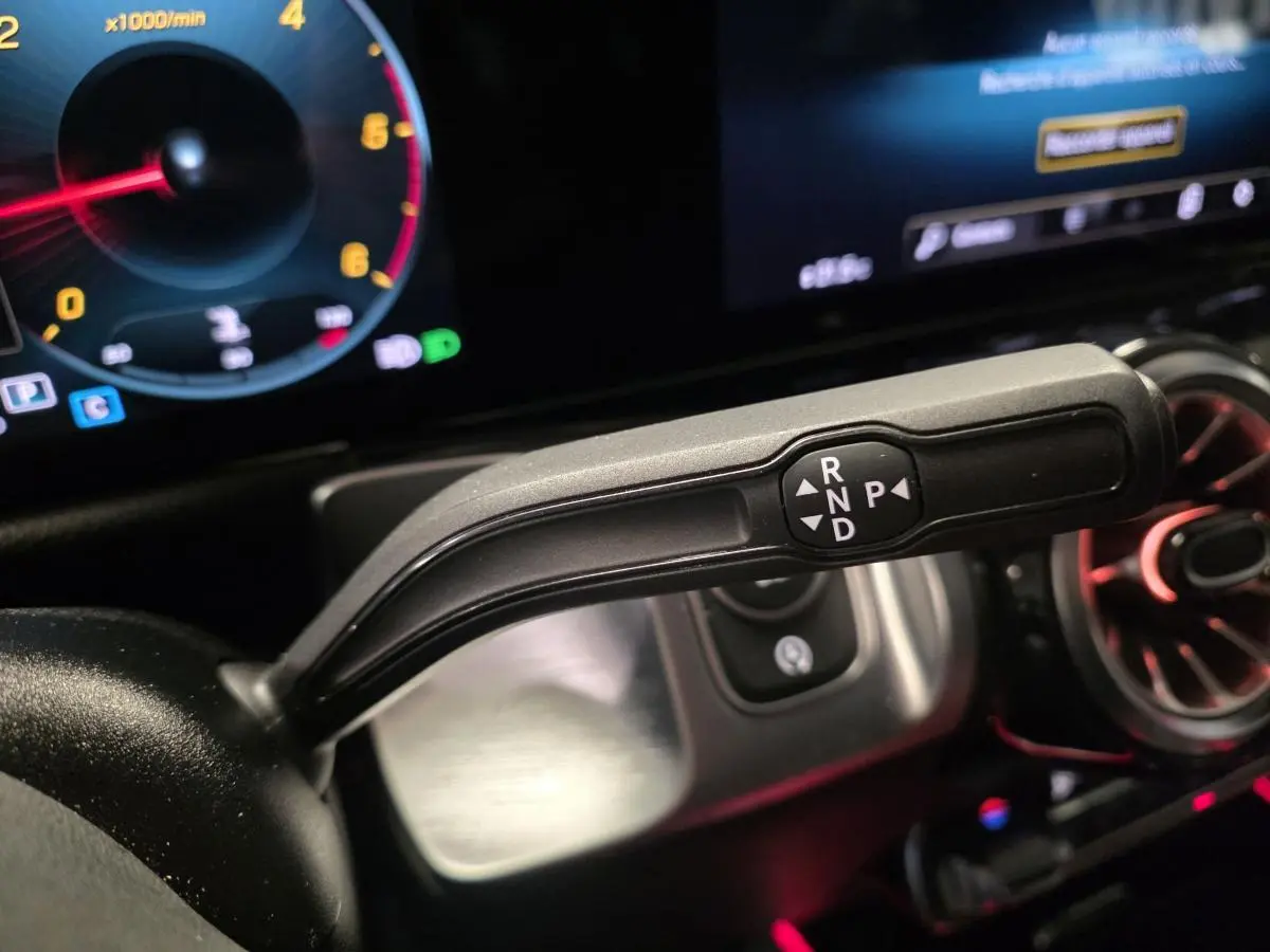 Le levier de boîte automatique noir du Mercedes GLB 200 d AMG Line, avec instrumentation digitale et éclairage d'ambiance rouge.