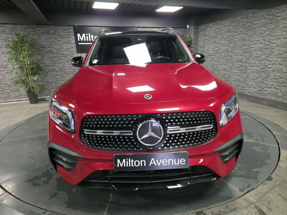 Vue avant d'un Mercedes GLB 200 d AMG Line rouge Patagonie avec calandre diamant et plaques Milton Avenue.