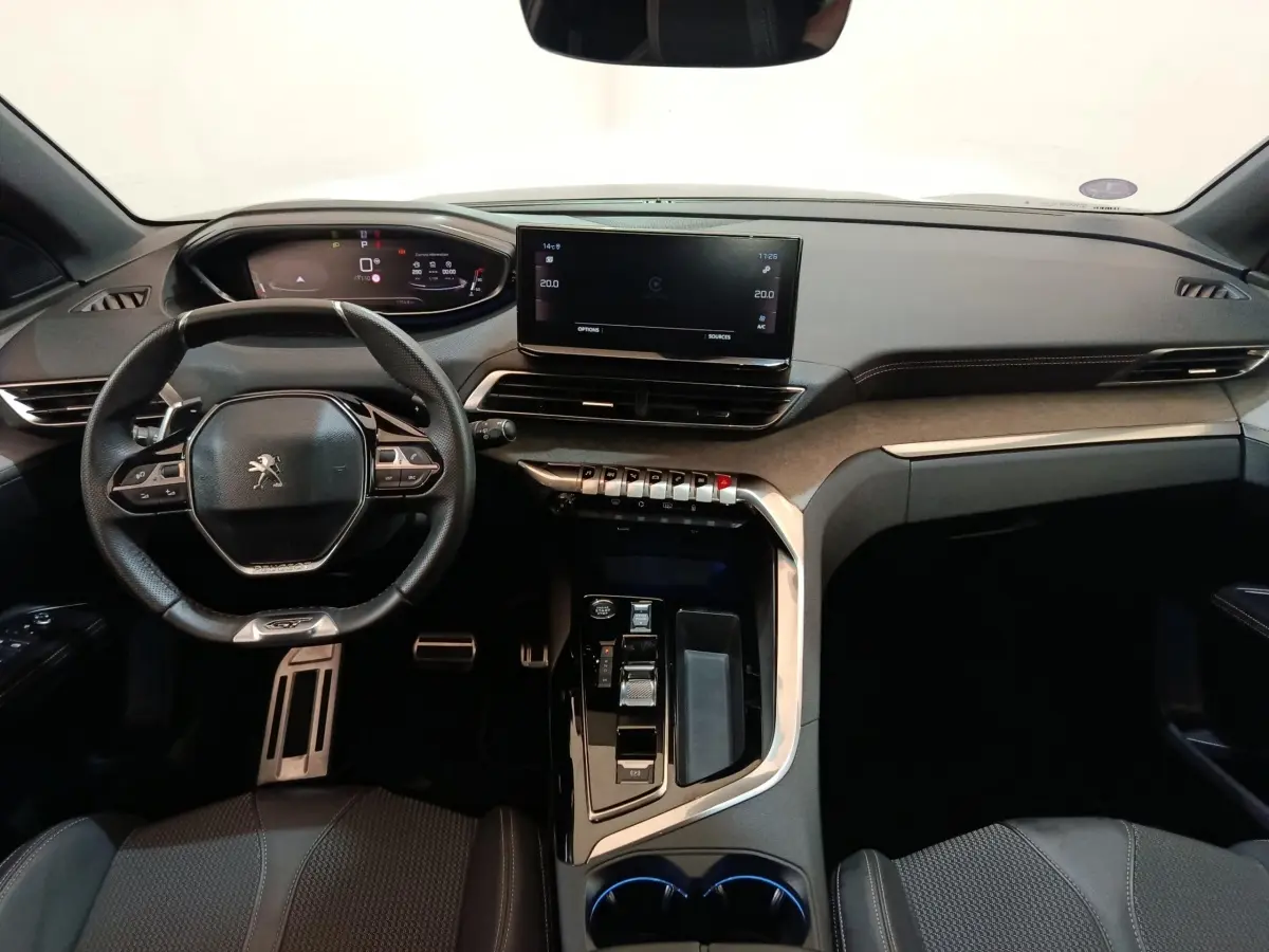 Vue intérieure du tableau de bord et volant cuir du Peugeot 5008 GT 2023, avec écran tactile central et commandes modernes.