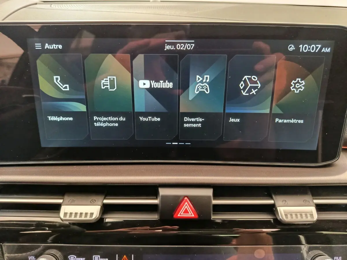 Écran tactile central du tableau de bord du Kia Sportage gris foncé, affichant menu multimédia et réglages.