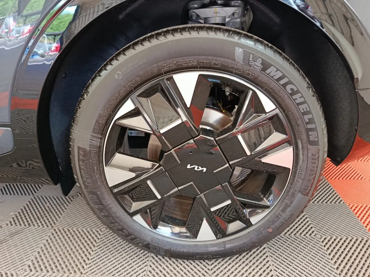 Gros plan sur la roue avant gauche gris foncé du Kia Sportage 2026 avec jante noire brillante au design géométrique.