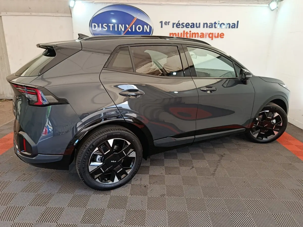 KIA Sportage gris foncé vu de profil droit, avec jantes noires et feux arrière LED distinctifs.