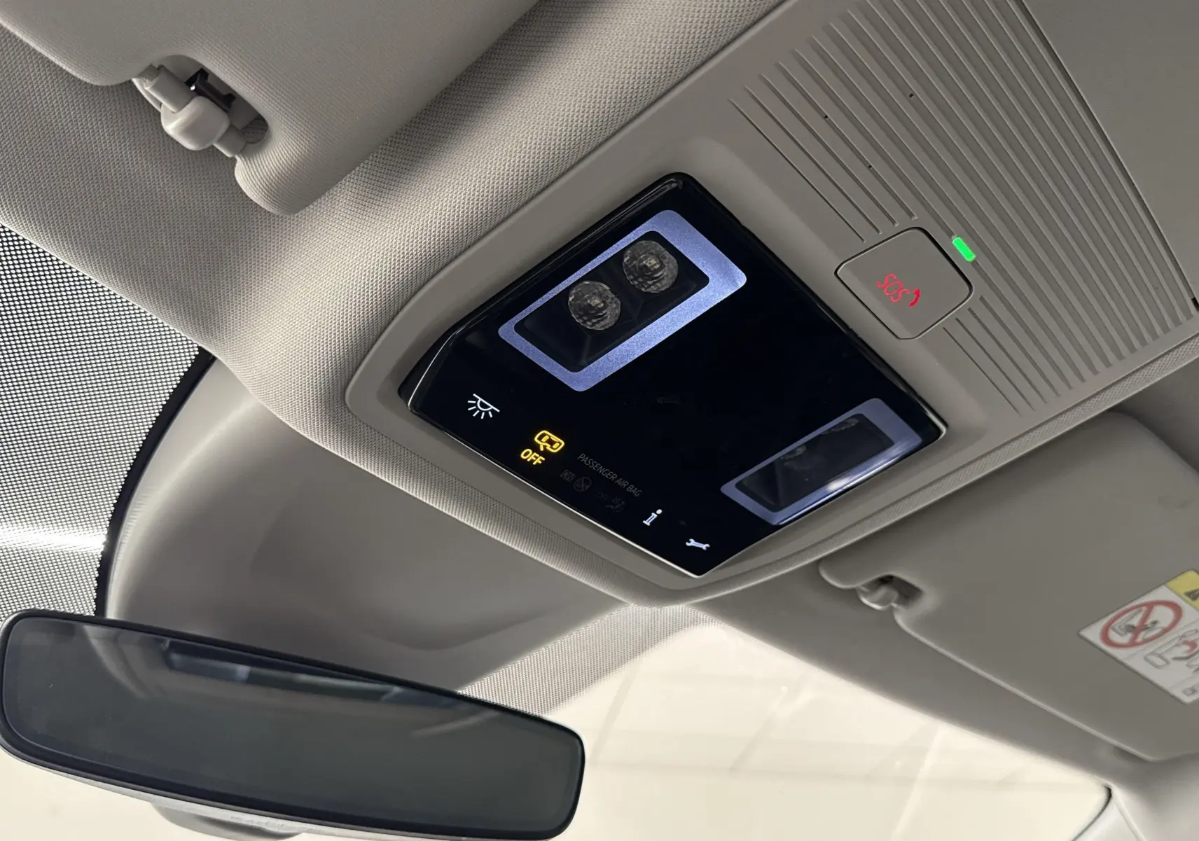 Plafonnier intérieur gris clair avec commandes et bouton SOS dans une Skoda Octavia Combi 2023 gris graphite.