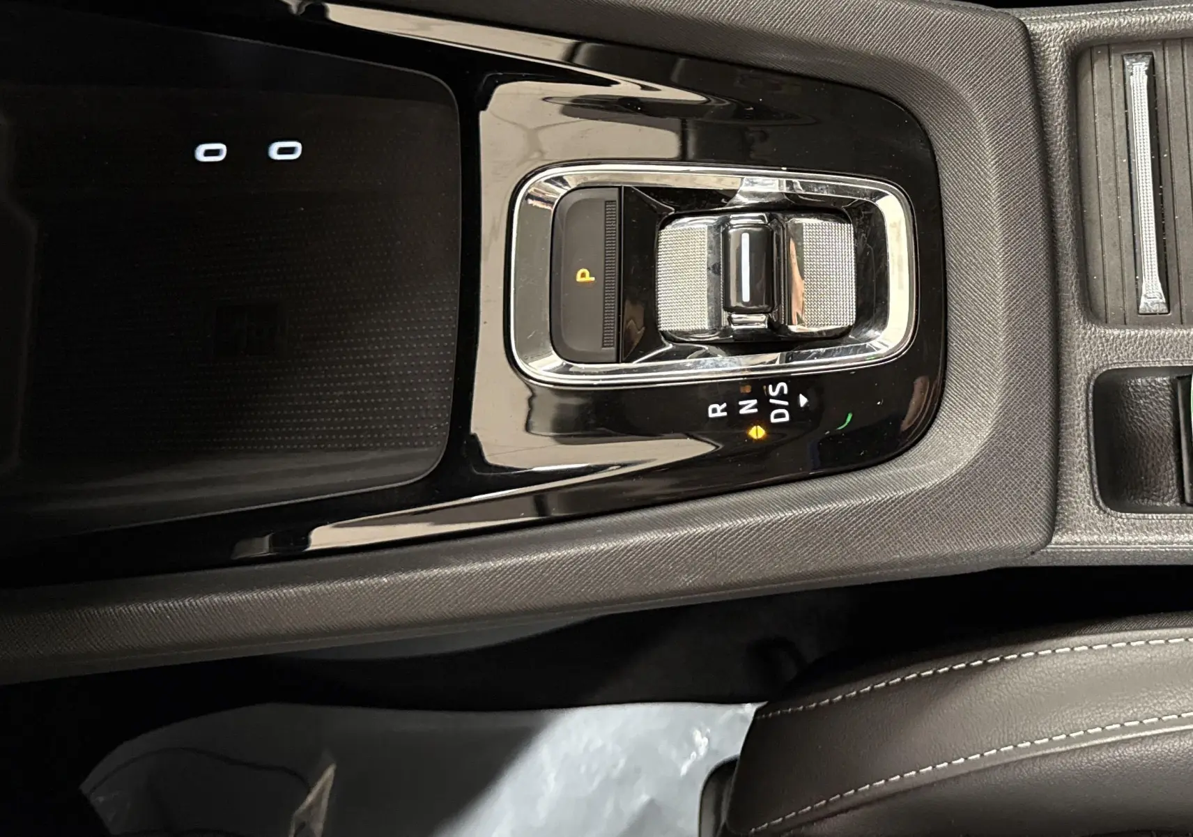 Vue rapprochée de la console centrale noire de la Skoda Octavia Combi 2023 avec levier de vitesses automatique et frein à main électrique.