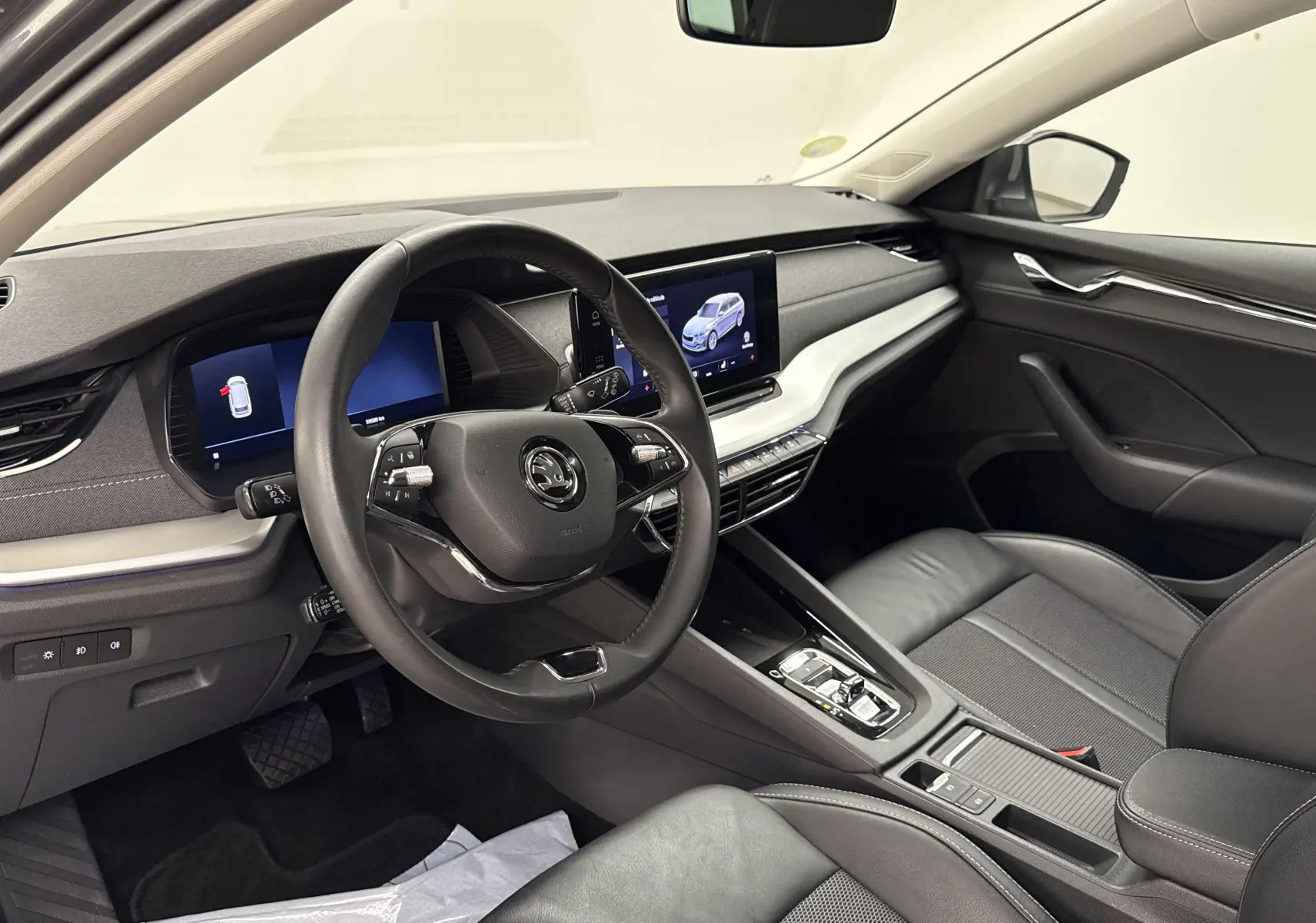 Intérieur de la Skoda Octavia Combi 2023 vu côté conducteur, avec tableau de bord numérique et sellerie noire.