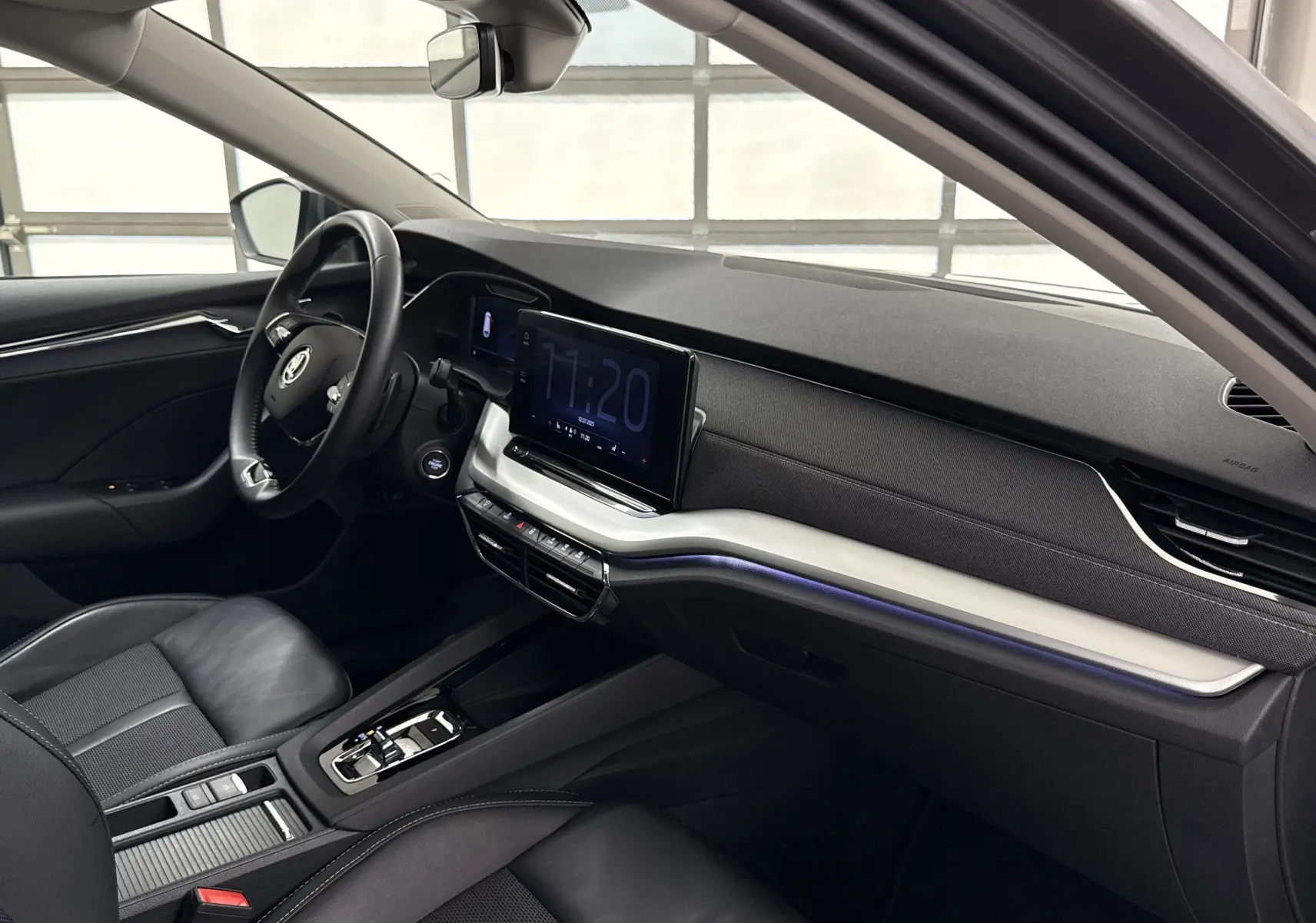 Intérieur avant droit de la Skoda Octavia Combi gris graphite 2023, tableau de bord moderne avec écran tactile central.