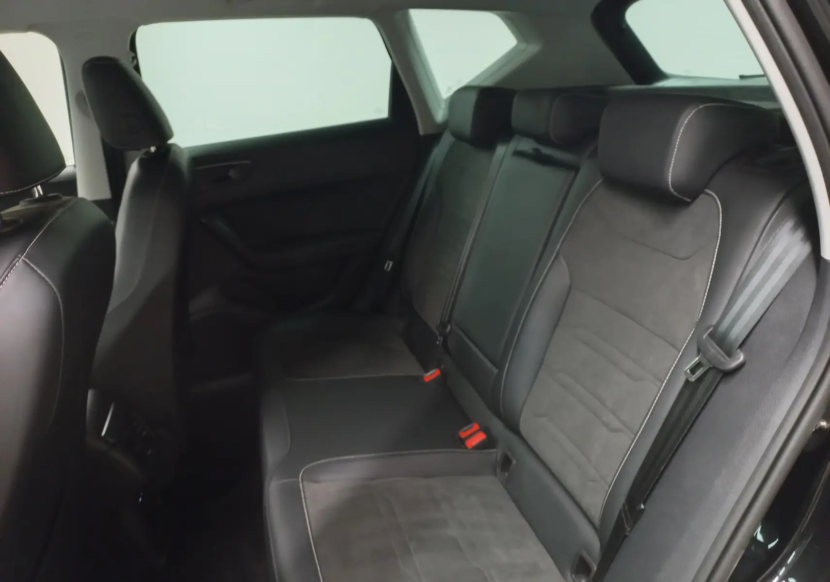Vue intérieure arrière du SEAT Ateca 2.0 TDI 150 DSG7 Copa, sièges en cuir noir et alcantara avec surpiqûres contrastées.
