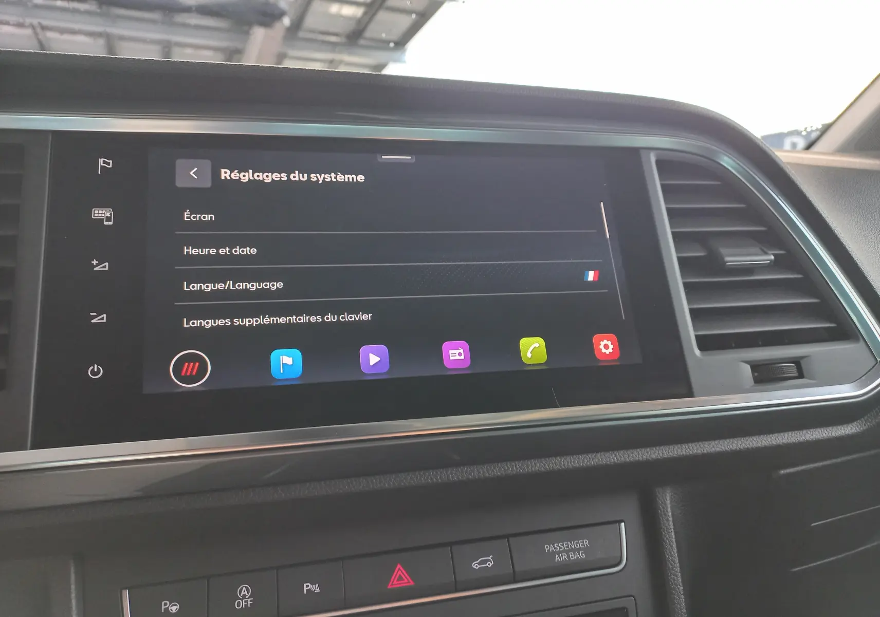 Écran tactile central du tableau de bord du SEAT Ateca 2025 avec réglages système affichés, ambiance intérieure noire.