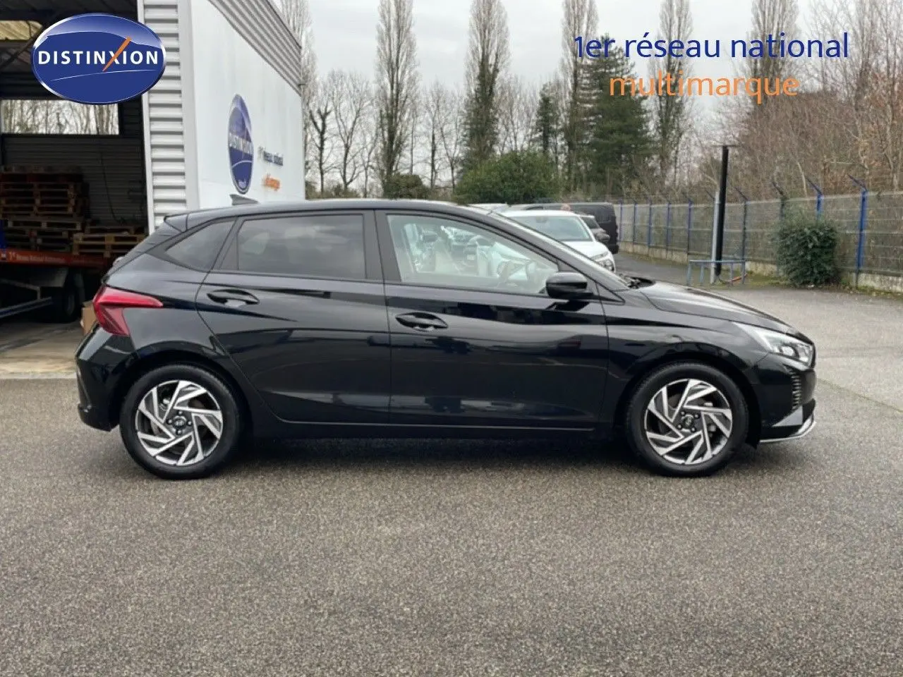 Profil côté gauche d'une Hyundai i20 2025 noire Phantom Metal, avec jantes alliage et lignes modernes visibles.