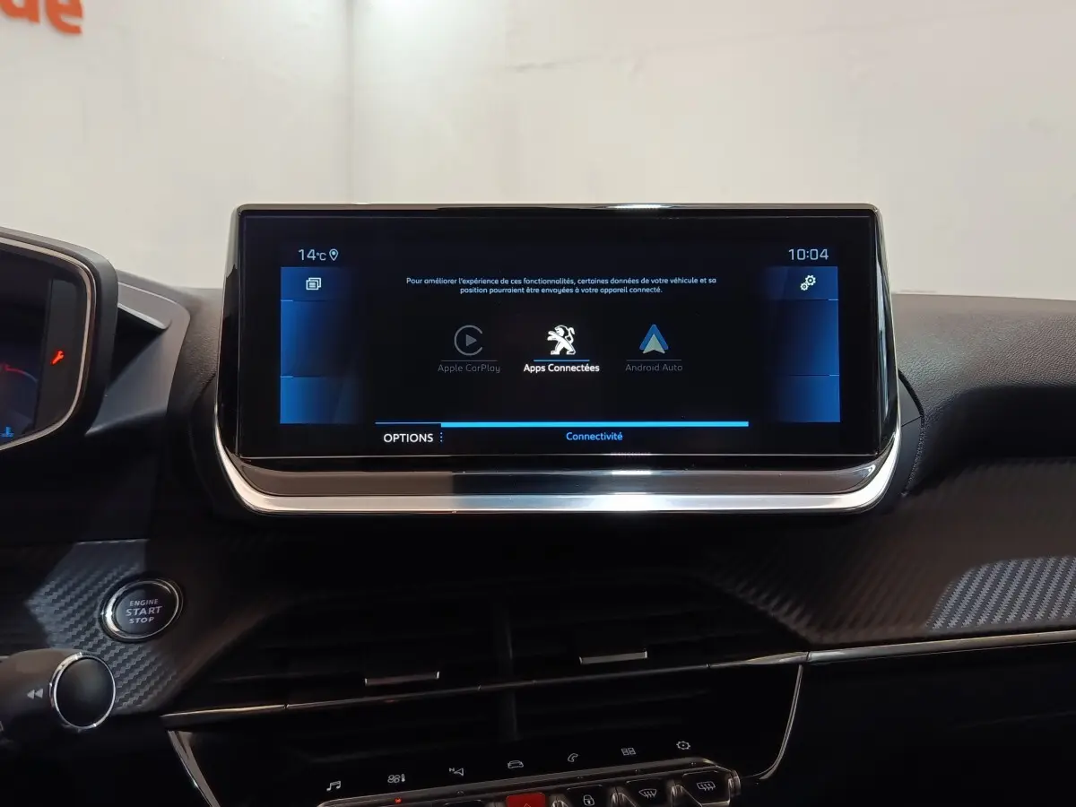 Vue intérieure centrée sur l’écran tactile 10 pouces du tableau de bord de la Peugeot 208 blanche, version Allure Business.