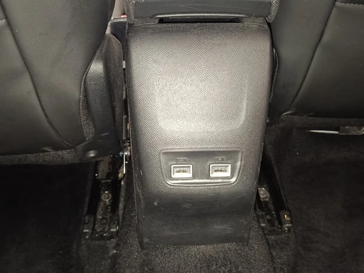 Vue rapprochée des ports USB arrière sur la console centrale noire d'une Peugeot 208 blanche de 2021.