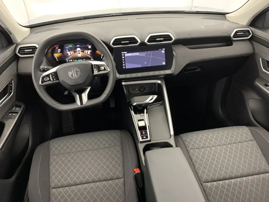 Vue intérieure avant du MG ZS 1.5 L Hybrid+ 2026, tableau de bord noir avec écran tactile 10,25'' et sièges tissu gris.