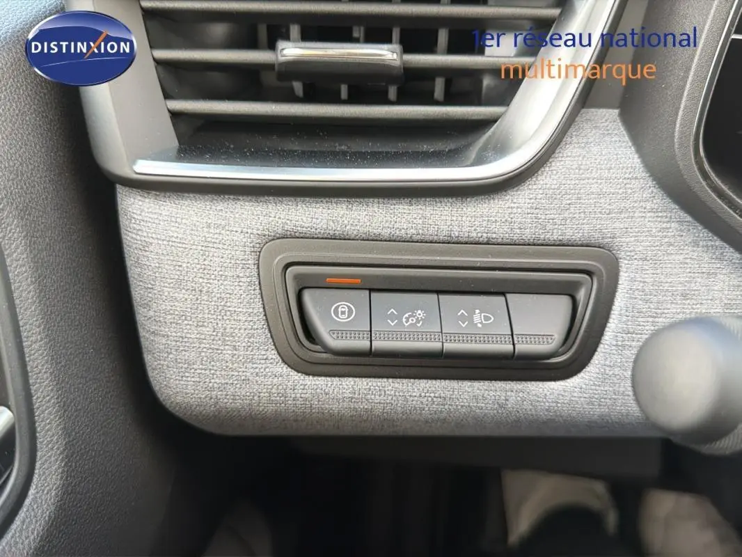 Détail du tableau de bord gris clair de la Renault Clio 2026 avec commandes d’éclairage et verrouillage.