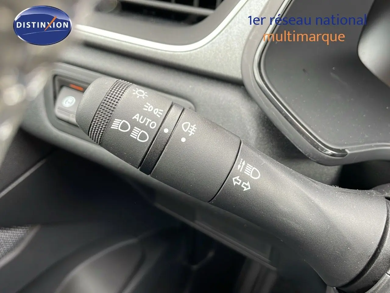 Gros plan sur la commande des phares et clignotants dans l'habitacle du Renault Captur blanc nacré toit beige 2025.