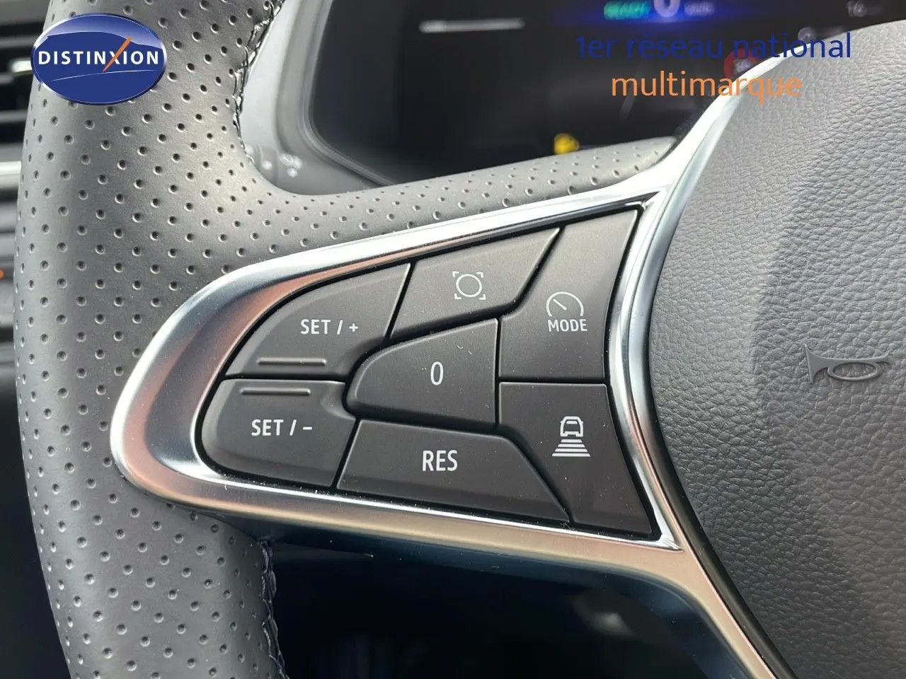 Gros plan sur les commandes au volant perforé du Renault Captur E-Tech hybride 2025, finition Technologie.