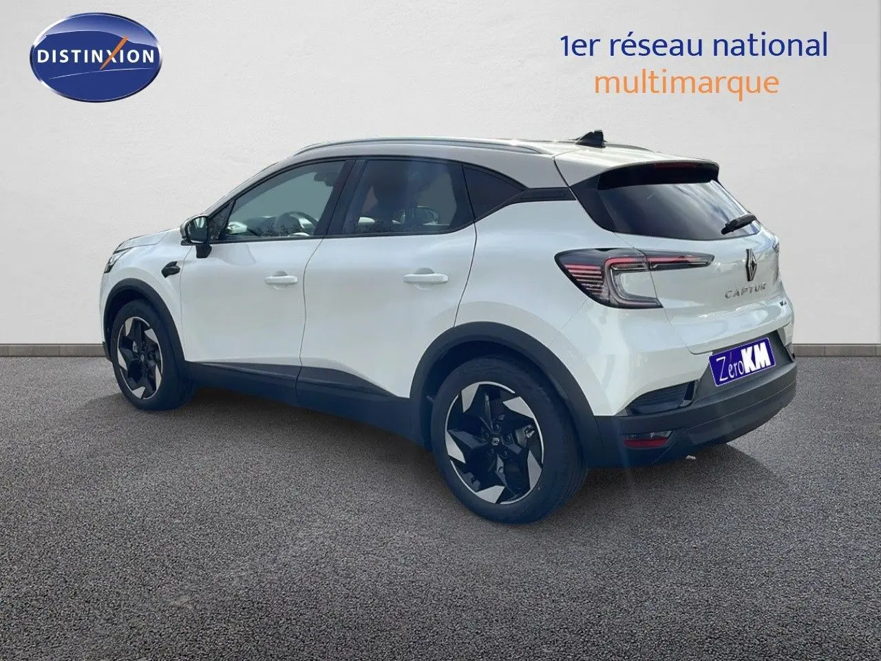 Renault Captur blanc nacré vue 3/4 arrière côté gauche avec toit beige et jantes noires distinctives.