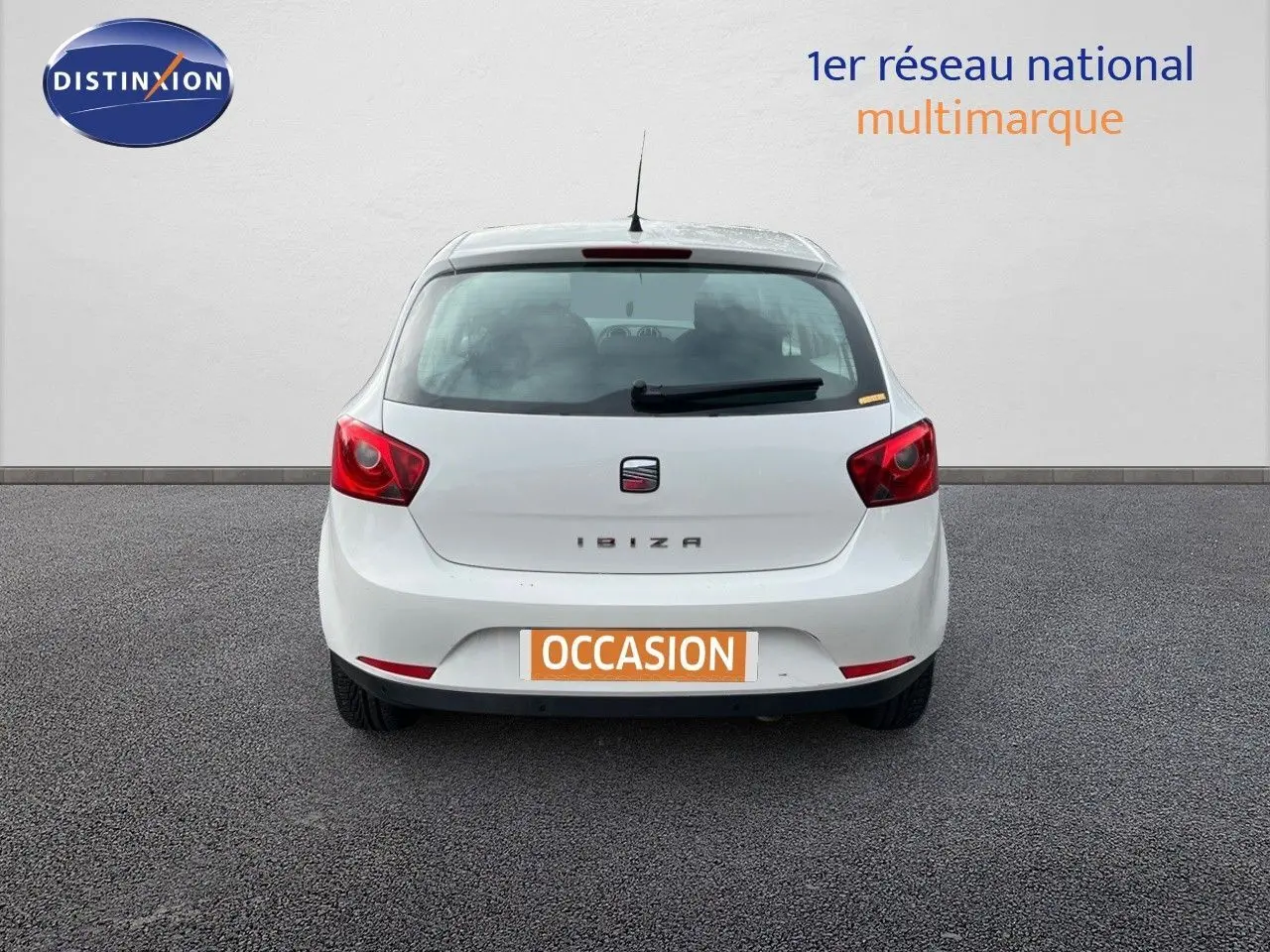 Vue arrière d'une SEAT Ibiza blanche 2010 avec feux rouges et plaque d'immatriculation orange "OCCASION".
