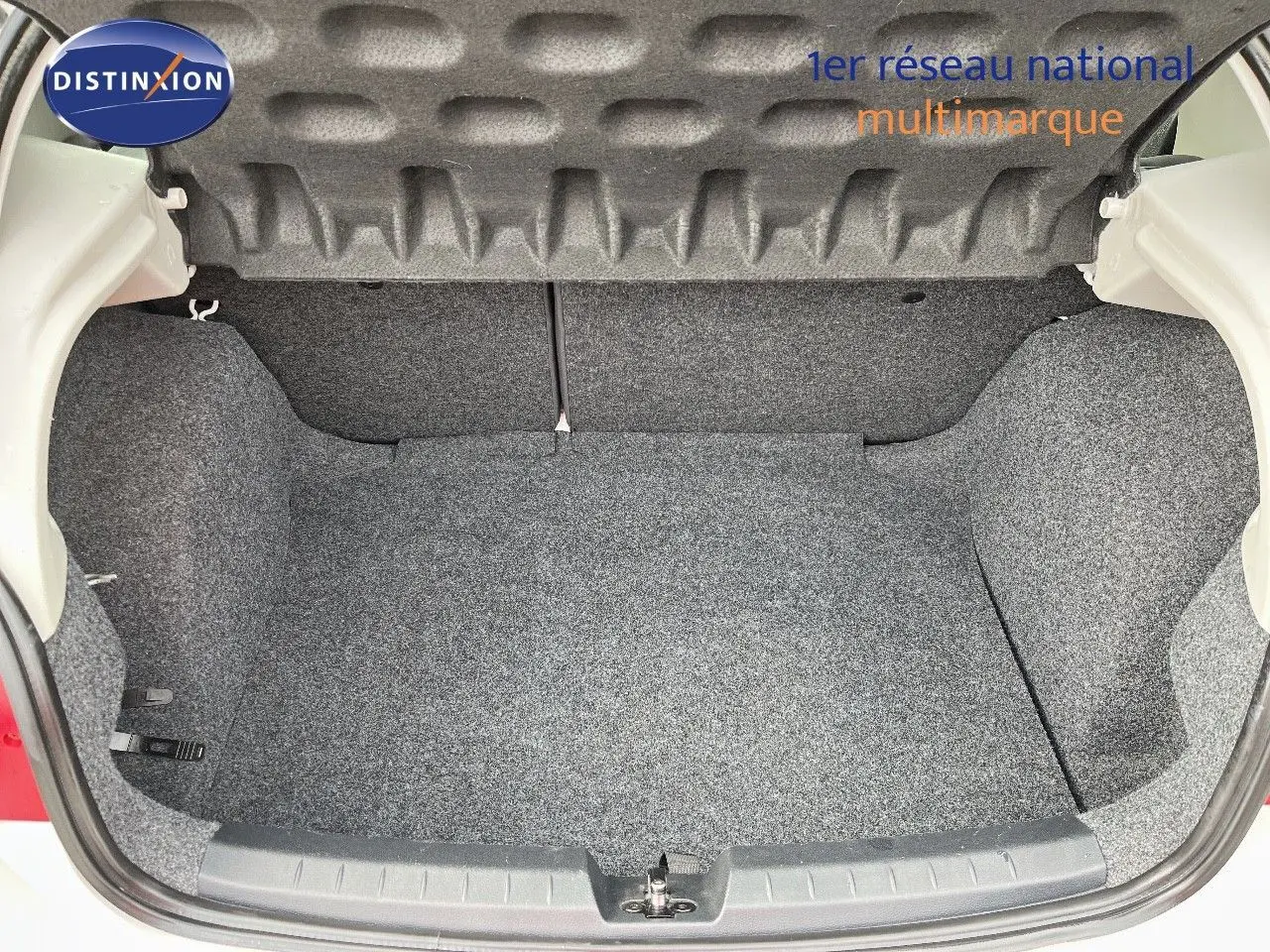 Coffre ouvert d'une SEAT Ibiza blanche 2010, vue arrière montrant l'espace de rangement vide et propre.