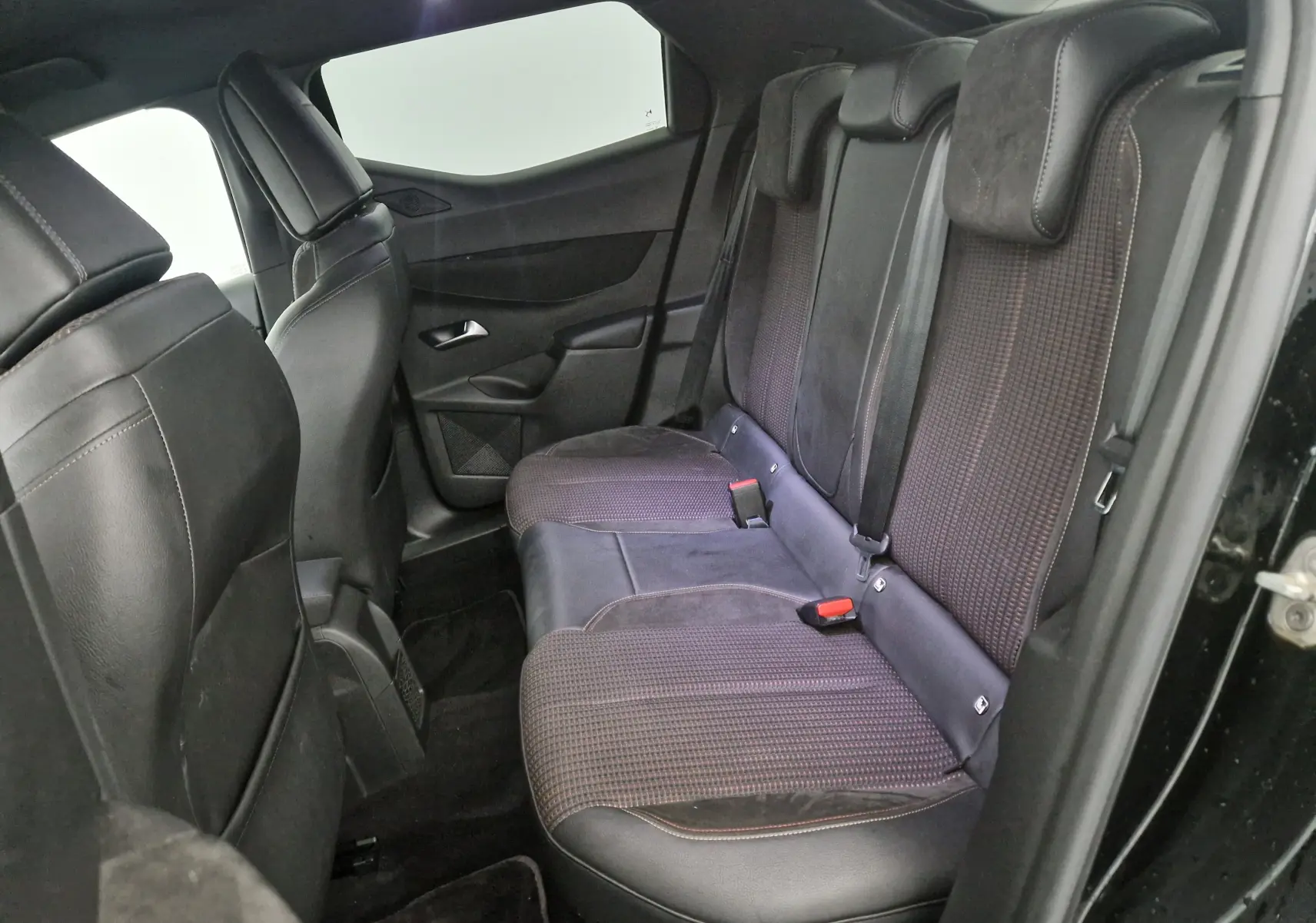 Vue latérale droite de l'habitacle arrière du DS3 Crossback noir, montrant les sièges en cuir et tissu bicolore.