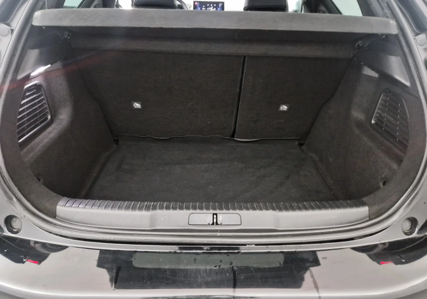 Coffre ouvert vu de l'arrière d'un DS3 Crossback noir, montrant un espace de chargement propre et bien fini.