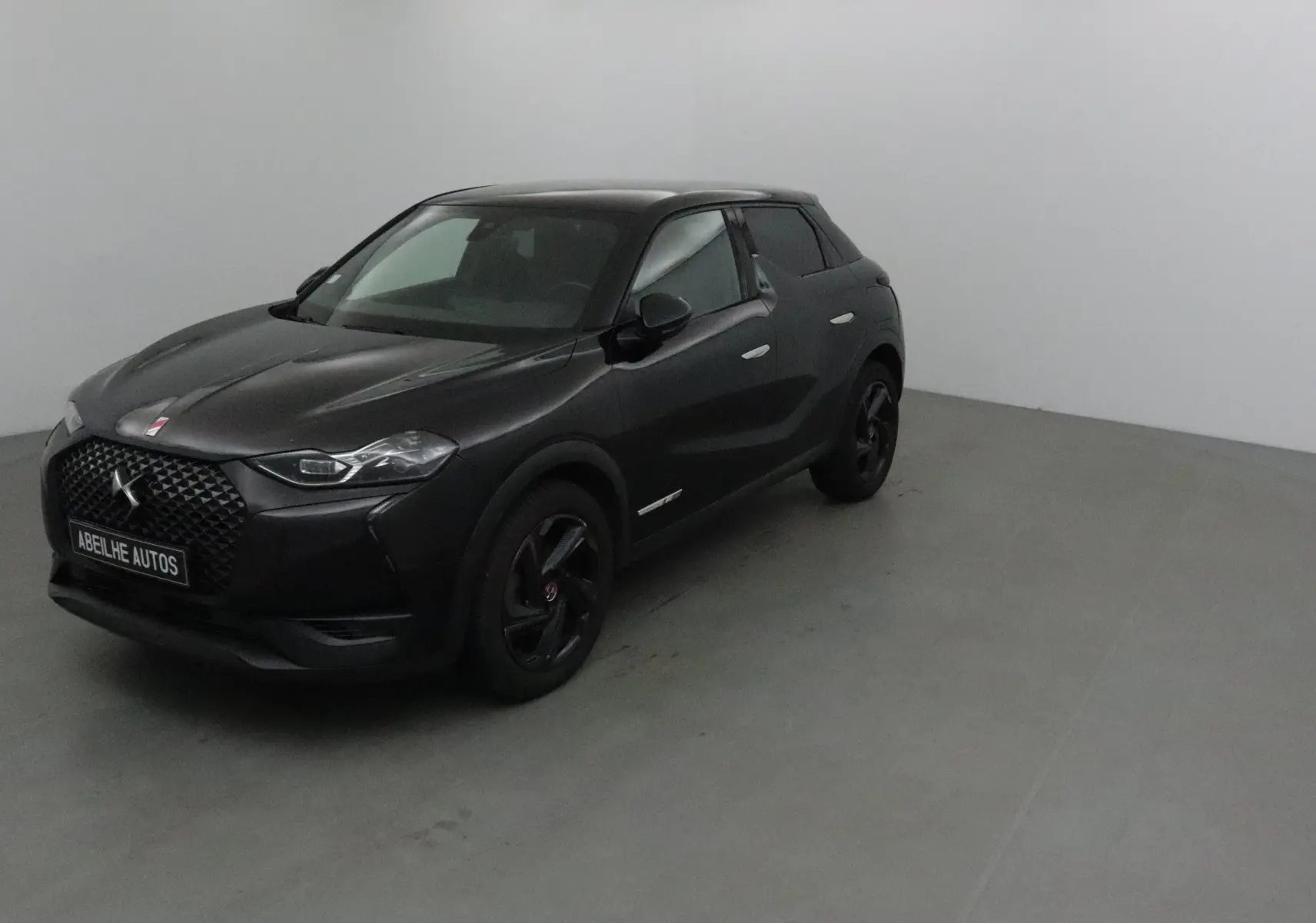 DS3 Crossback noir en 3/4 avant droit, mettant en valeur sa calandre distinctive et ses jantes noires.