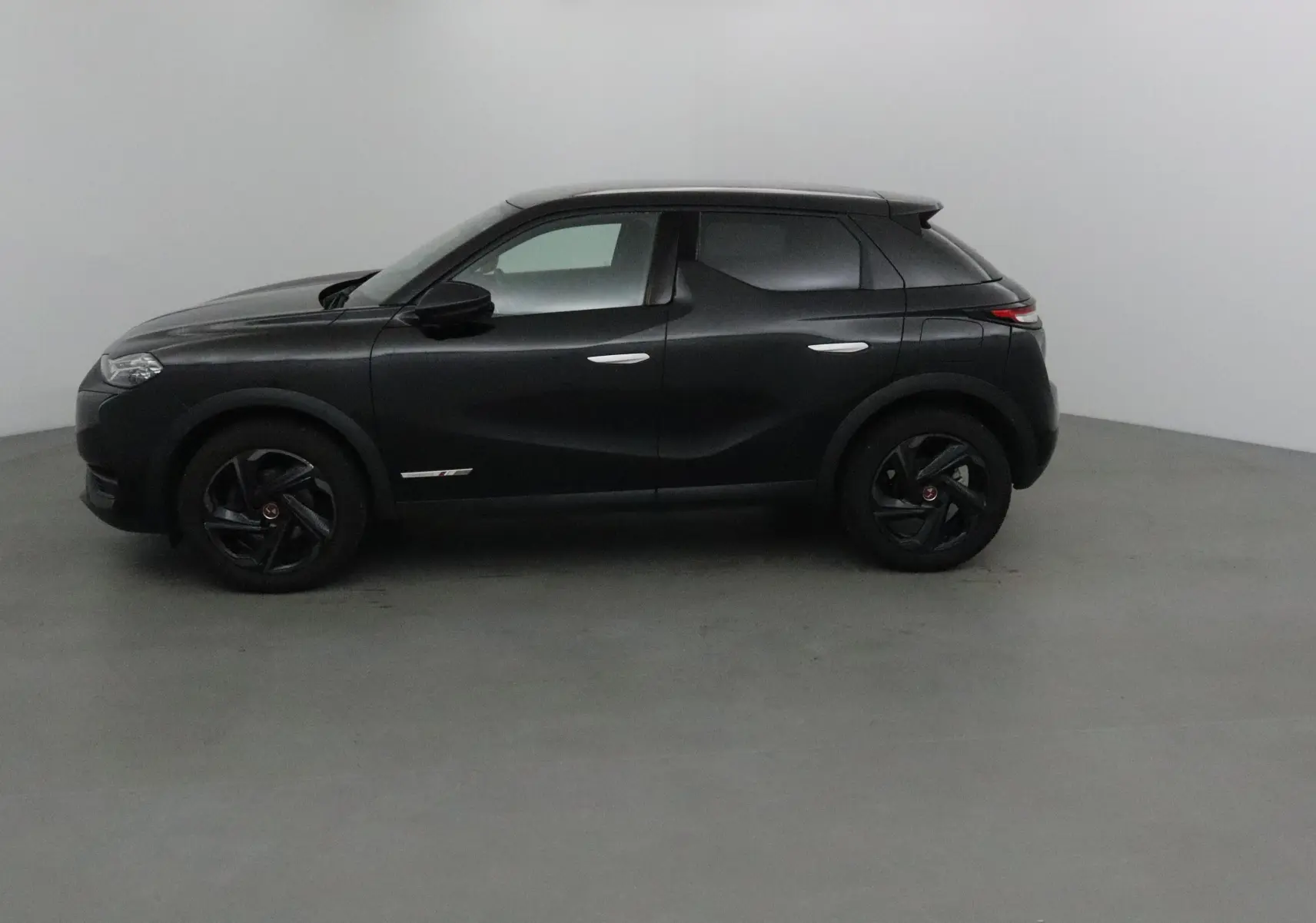 Profil côté gauche du DS3 Crossback noir 2019, soulignant ses jantes noires et lignes sculptées élégantes.