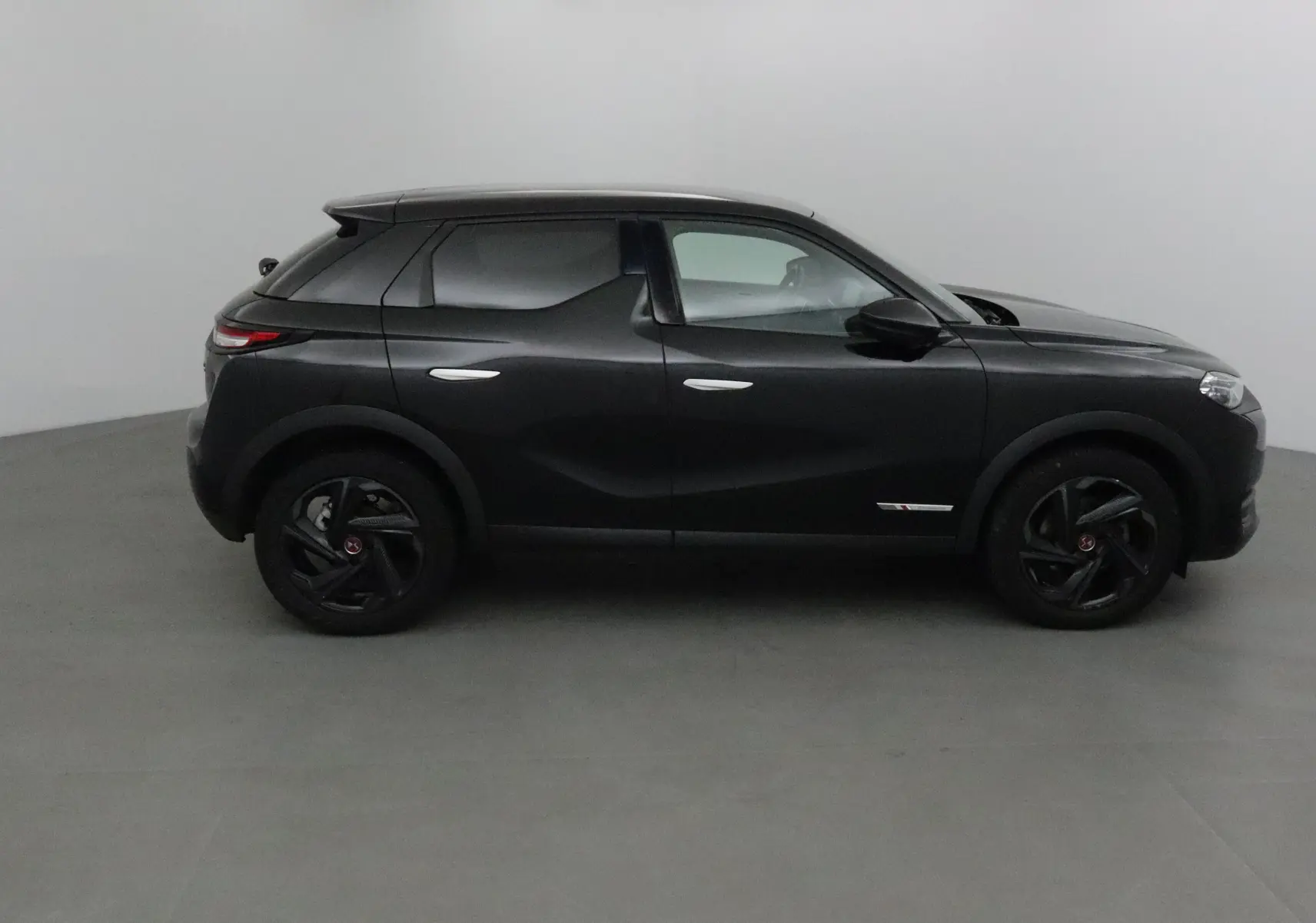 Profil côté droit du DS3 Crossback noir 2019 avec jantes noires et lignes sculptées distinctives.