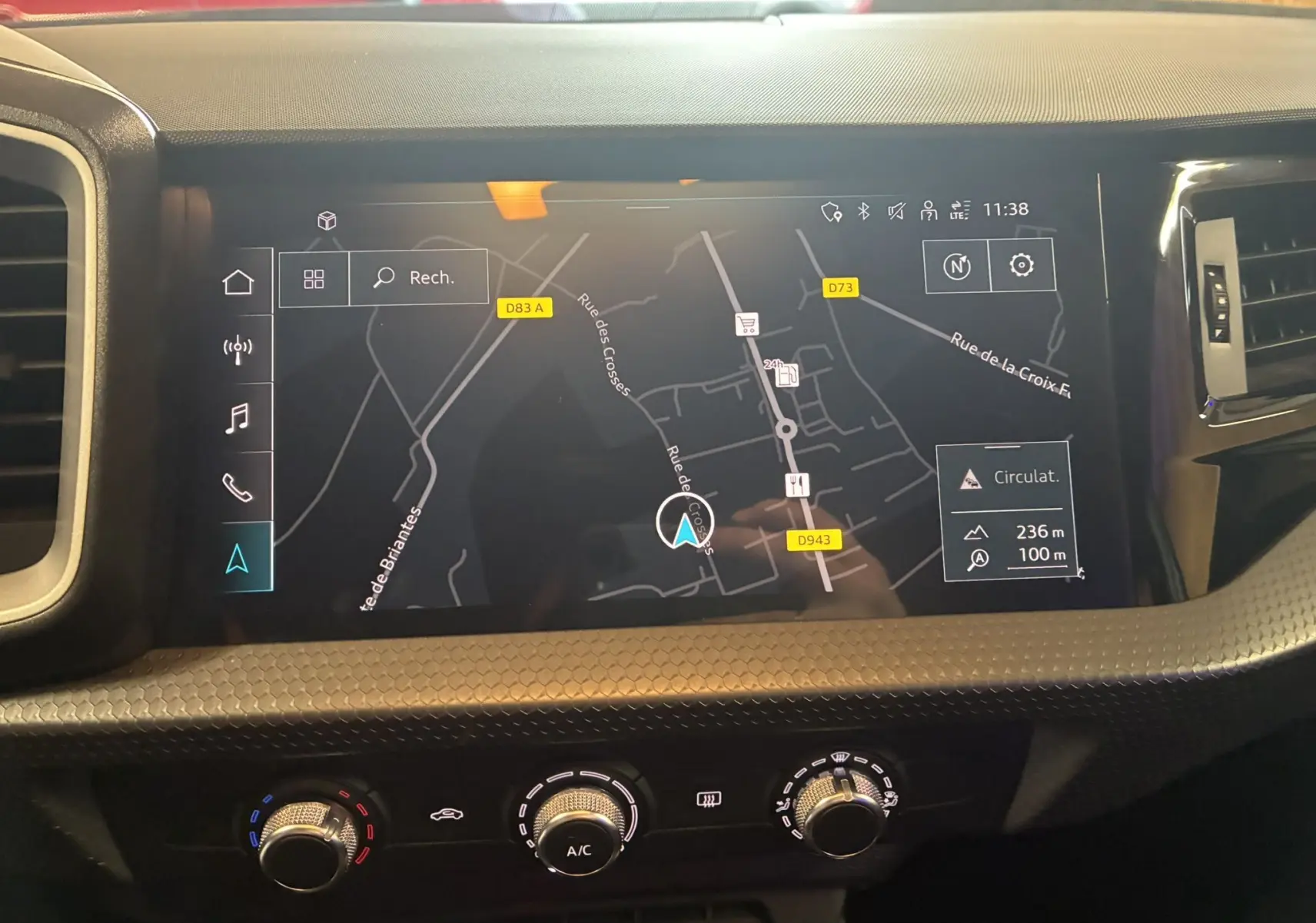 Vue rapprochée de l'écran GPS tactile et des commandes de climatisation de l'Audi A1 blanche de 2022.