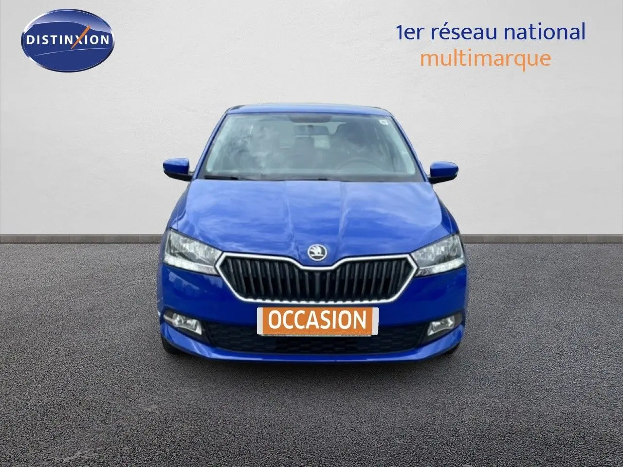 SKODA Fabia 1.0 TSI 95CH Active bleu énergie vue 3/4 avant devant un garage AD Expert.