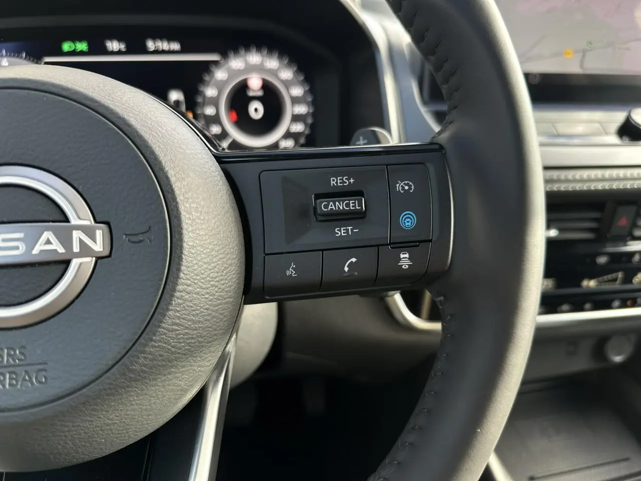 Gros plan sur le volant cuir noir du Nissan Qashqai 2025 avec commandes de régulateur de vitesse et assistance au conducteur.