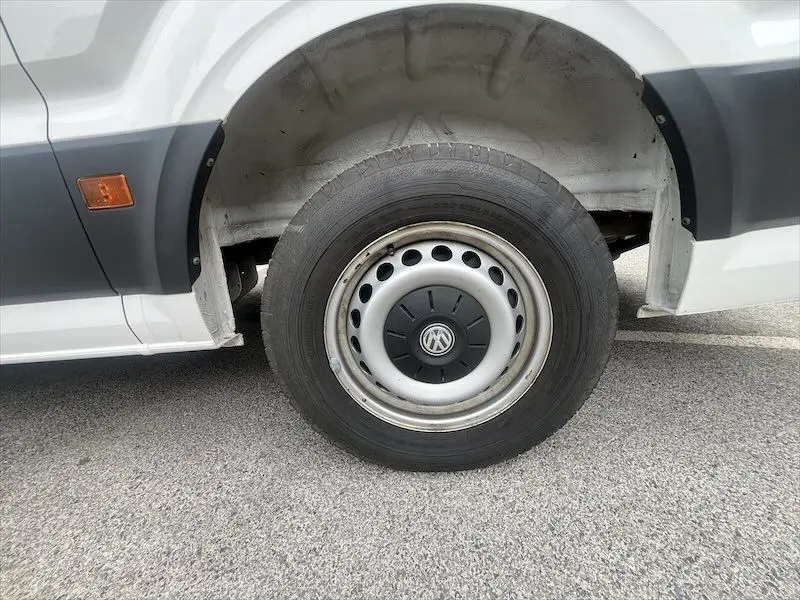 Gros plan sur la roue avant gauche blanche d’un Volkswagen Crafter Fourgon L3H3 Business Line 2019 avec logo VW visible.