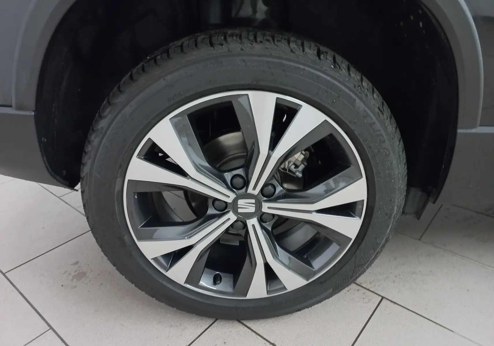 Gros plan sur la jante alliage 18'' usinée du SEAT Ateca noir Magic Nacré, mettant en valeur son design moderne.