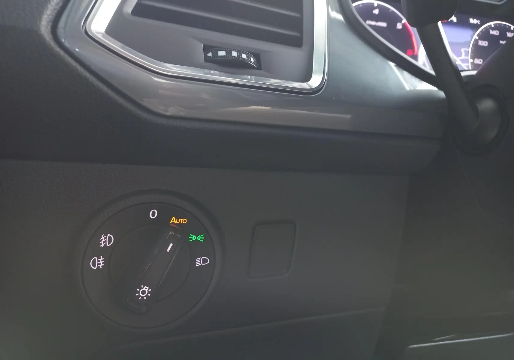 Détail du bouton de commande des phares sur le tableau de bord d'un SEAT Ateca 2.0 TDI noir Magic Nacré, 2025.