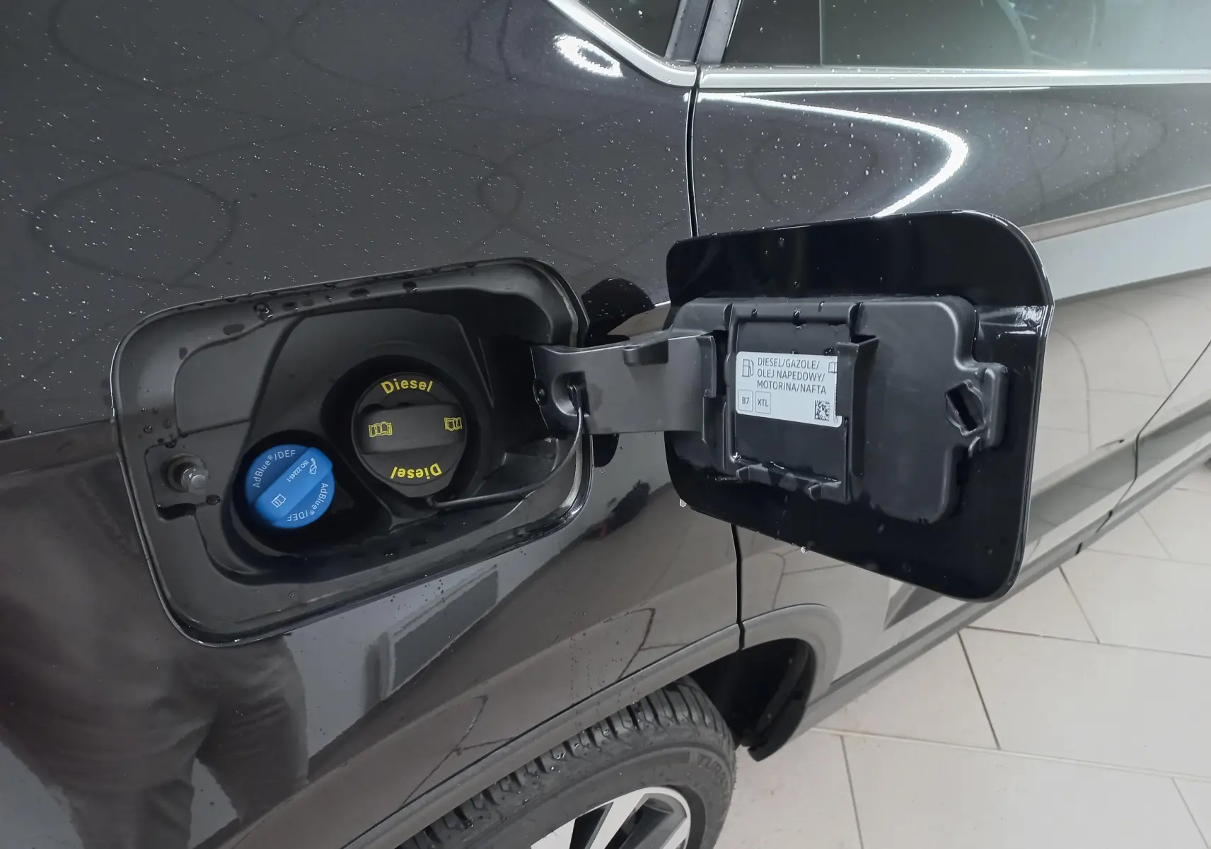Bouchon de réservoir diesel ouvert sur le côté gauche d’un SEAT Ateca noir Magic Nacré 2025.
