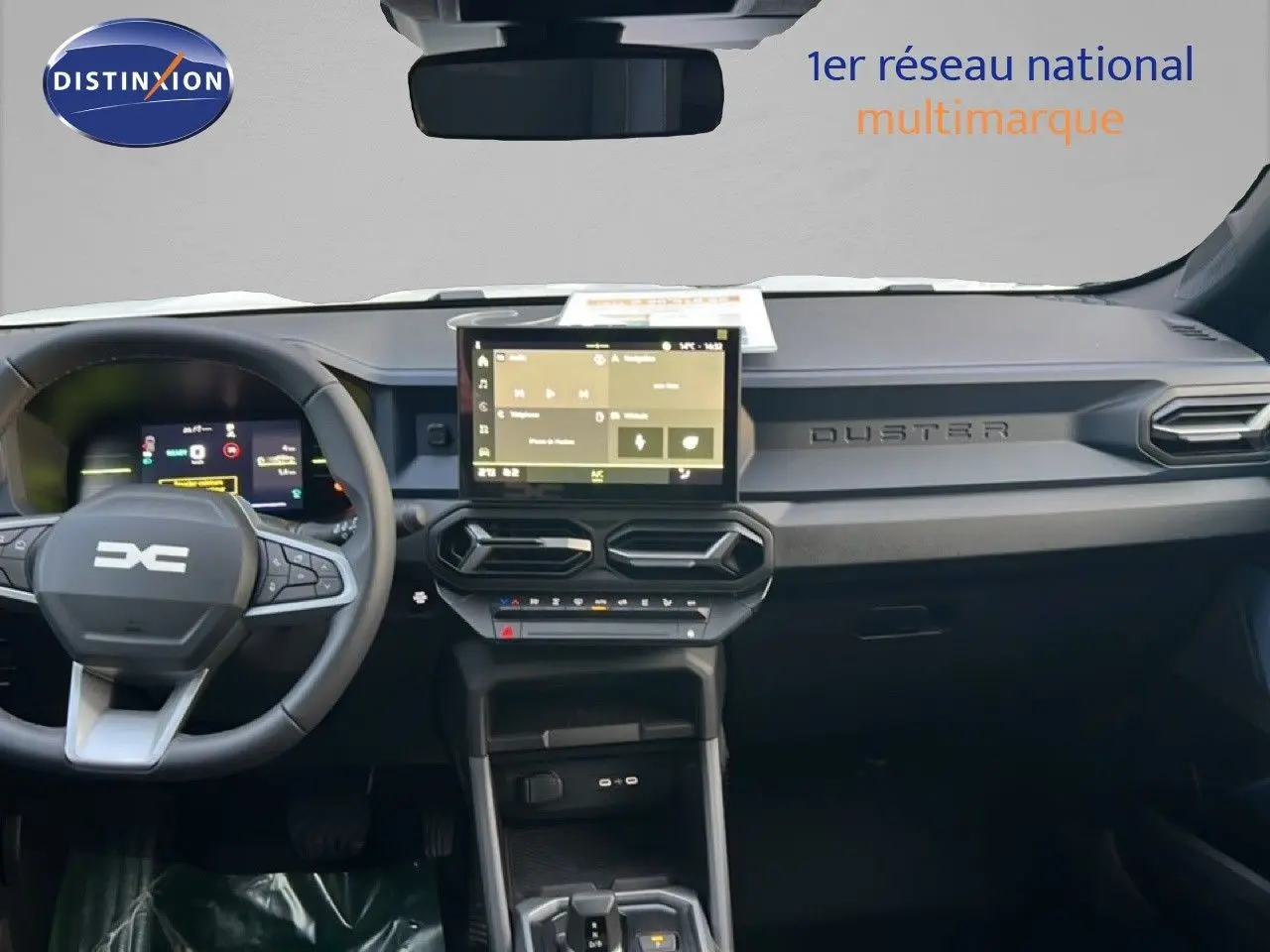 Vue intérieure frontale du tableau de bord du Dacia Duster Hybrid 140 Journey avec écran tactile central et volant multifonction.