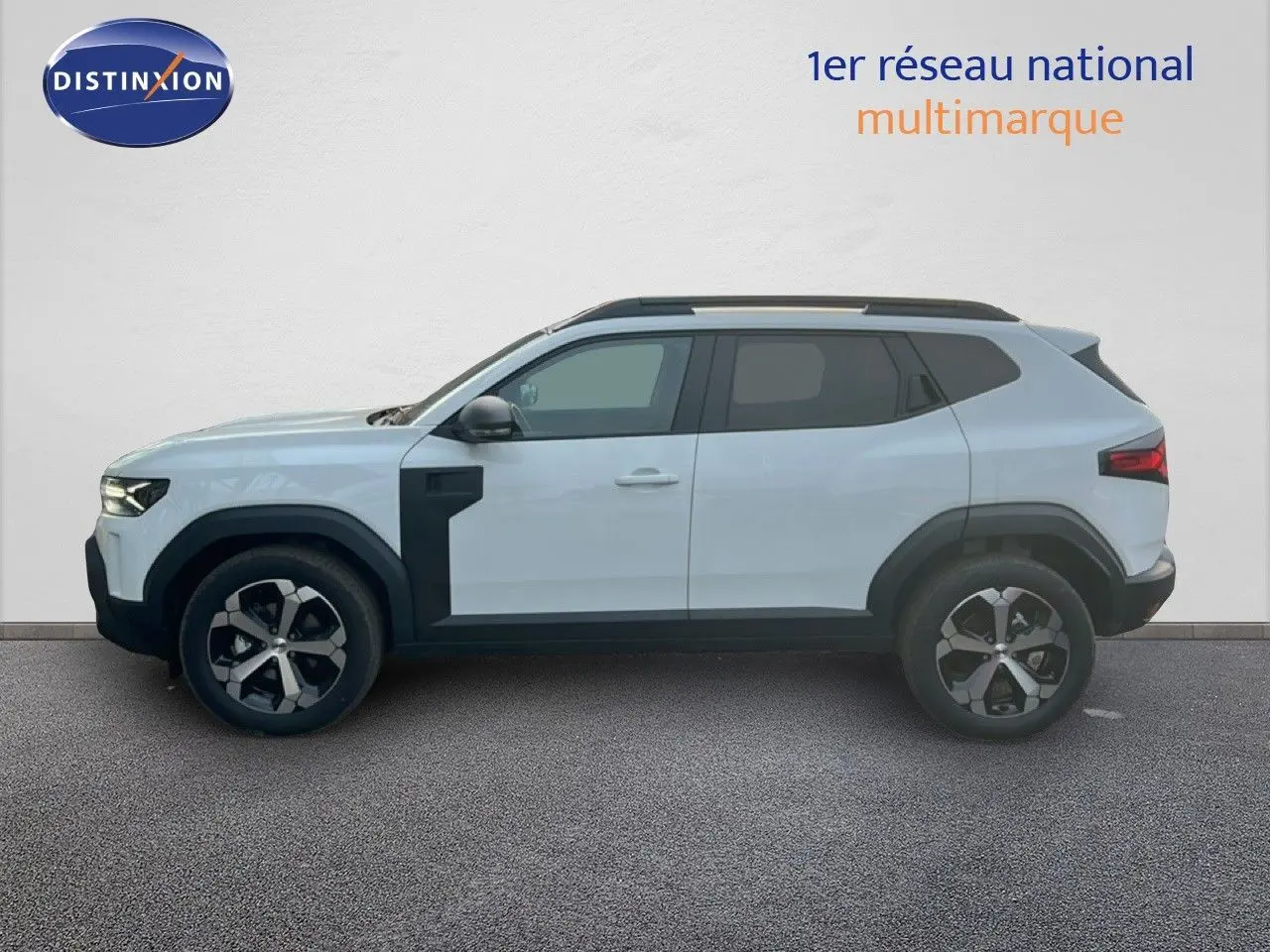 Vue latérale droite du Dacia Duster Hybrid 140 Journey blanc Glacier avec jantes alliage 18 pouces et barres de toit.
