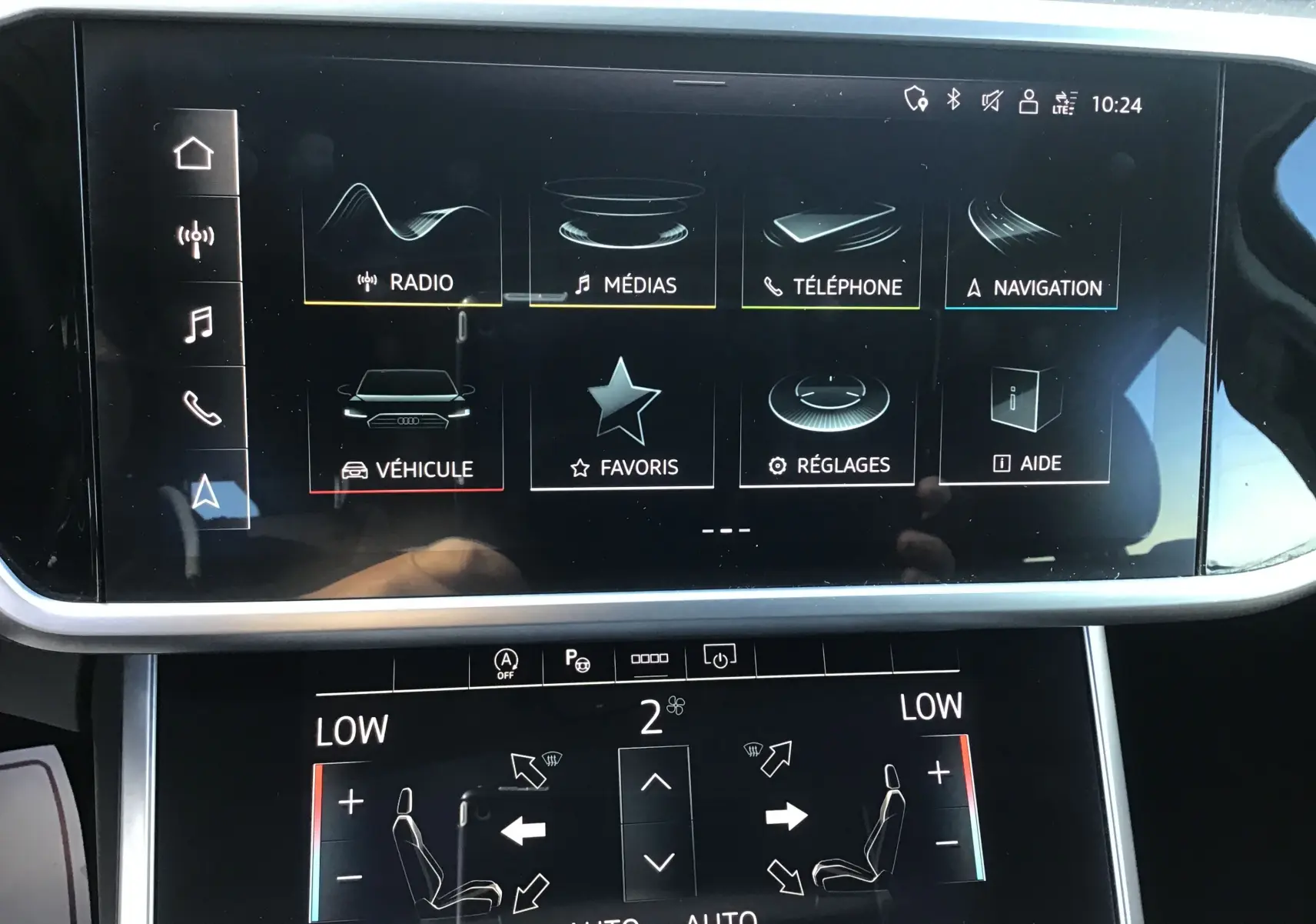 Écran tactile central de l'Audi A6 Avant 2022 blanc glacier, affichant le menu multimédia et les réglages climatiques.