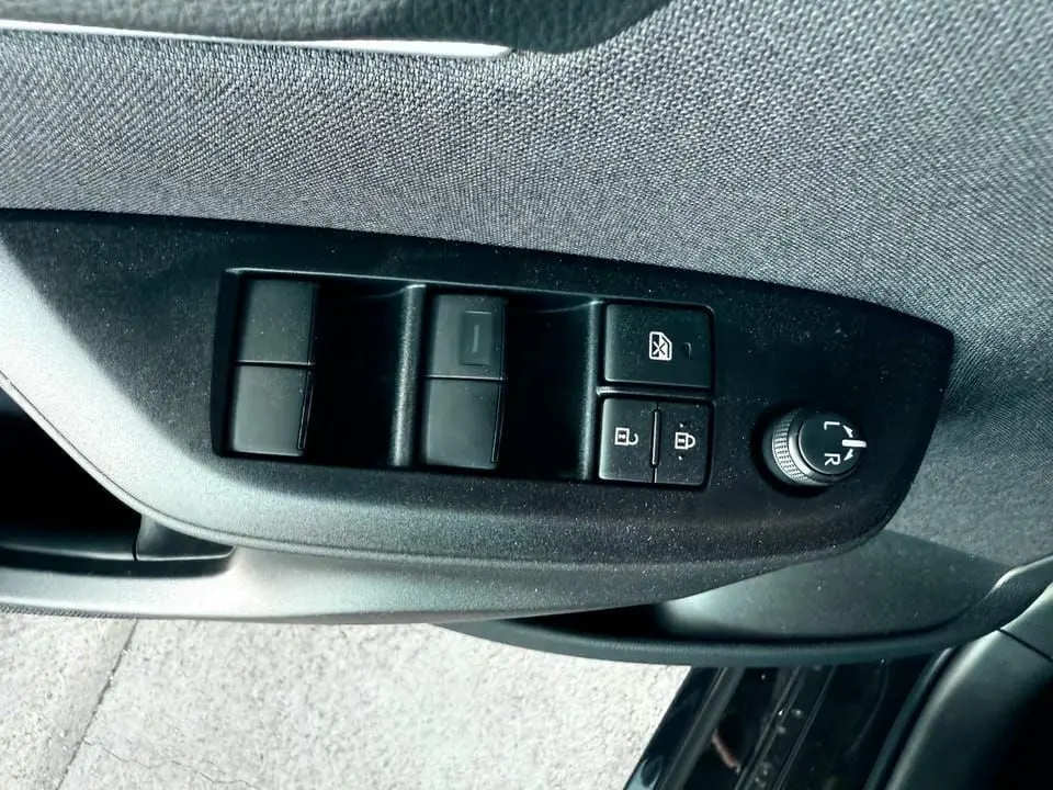 Panneau de commandes des vitres et rétroviseurs côté conducteur de la Toyota Yaris Hybrid 116ch noir 2025.